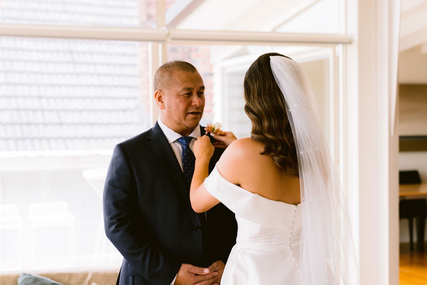 A tender moment between a bride and groom during their wedding ceremony preparations.