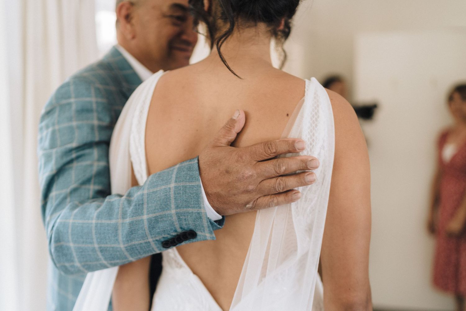 Emotional first look moments between individuals in a light-filled interior space.