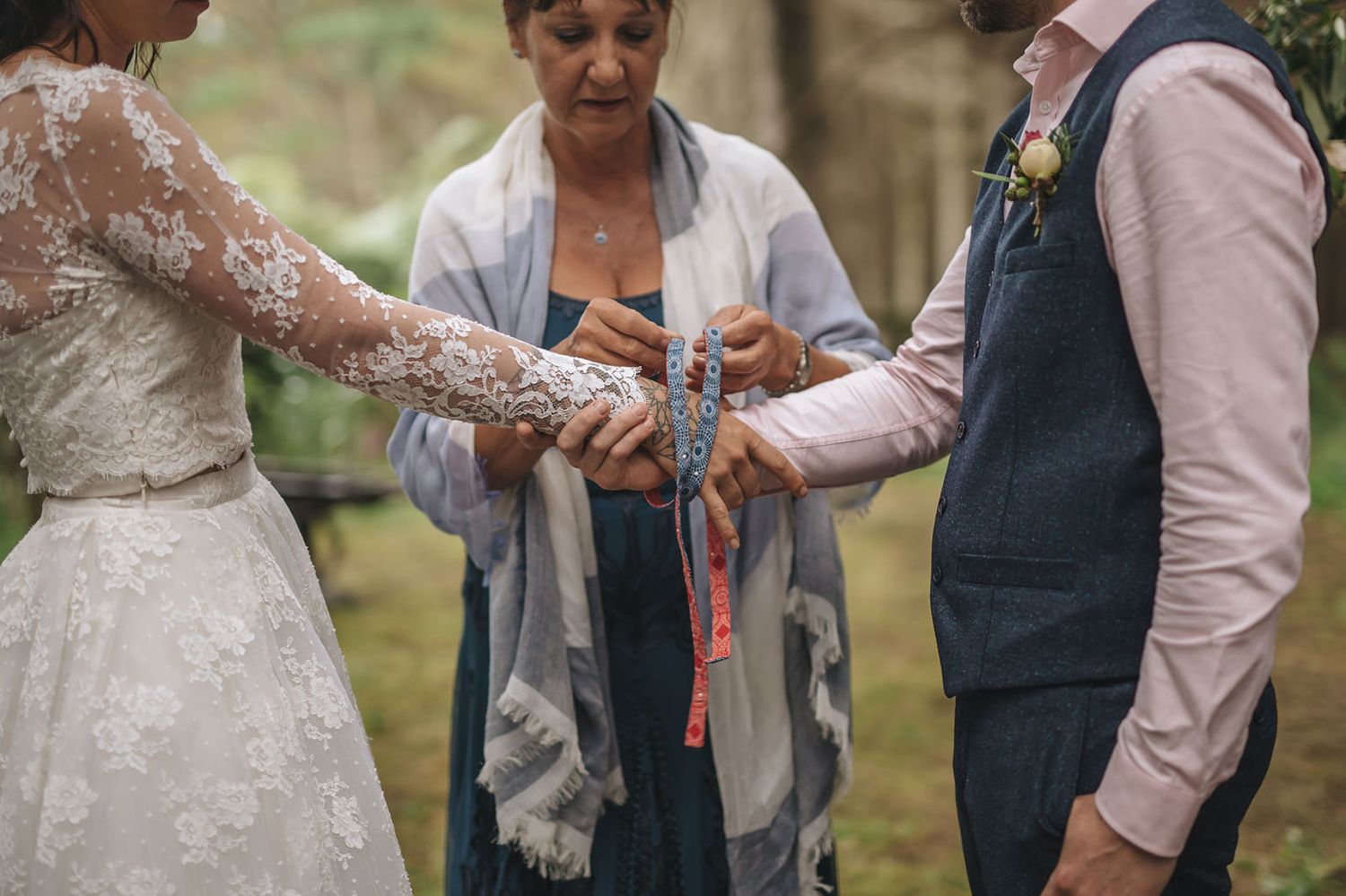 Couple holding hands while being celebrated during their garden wedding ceremony.