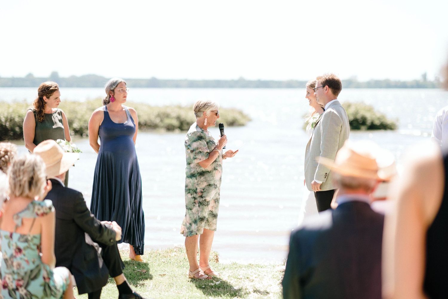 Wedding guests gathered in formal attire at an outdoor waterfront celebration.