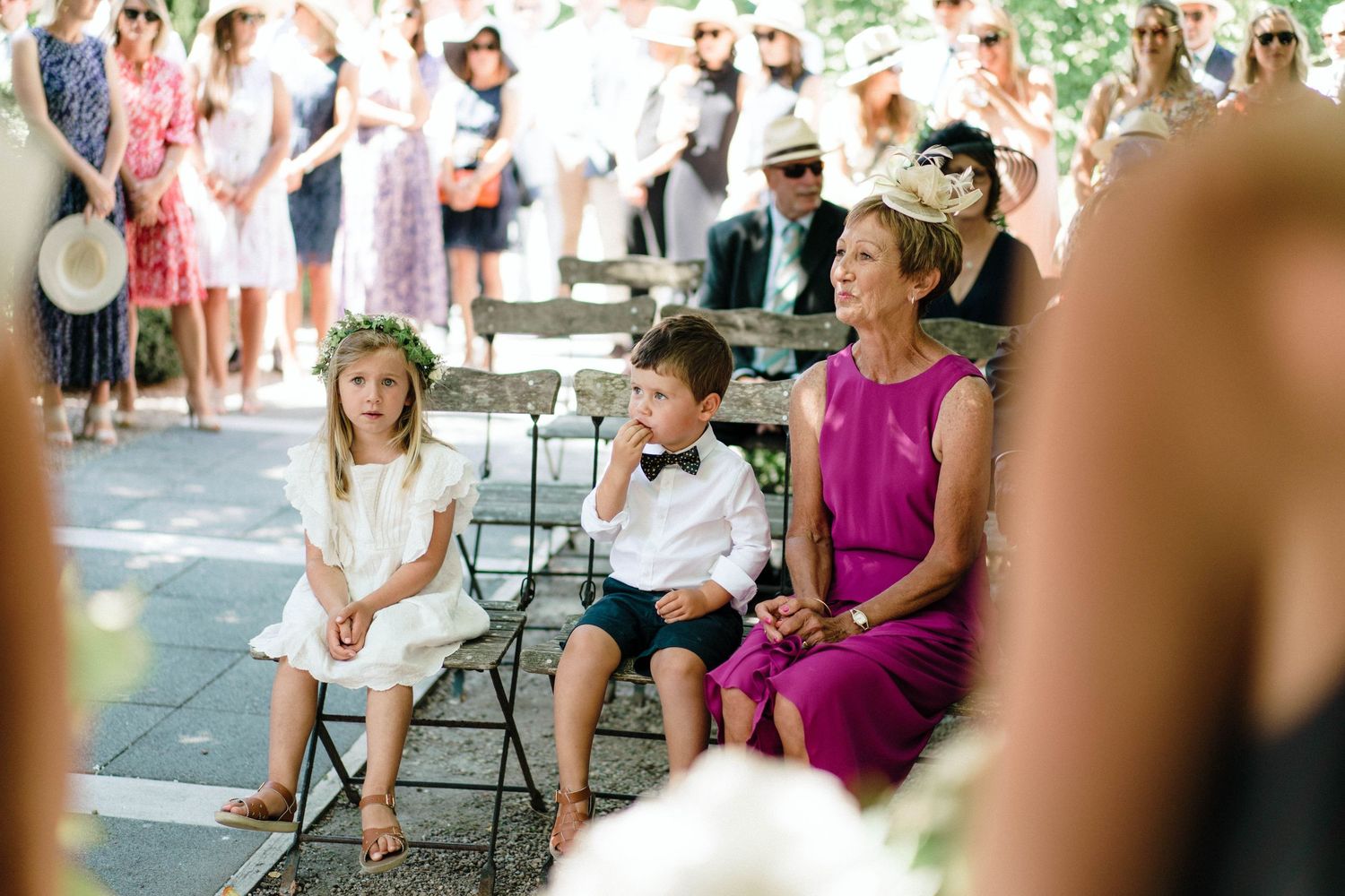 Guests seated in white chairs during an outdoor summer garden party event.