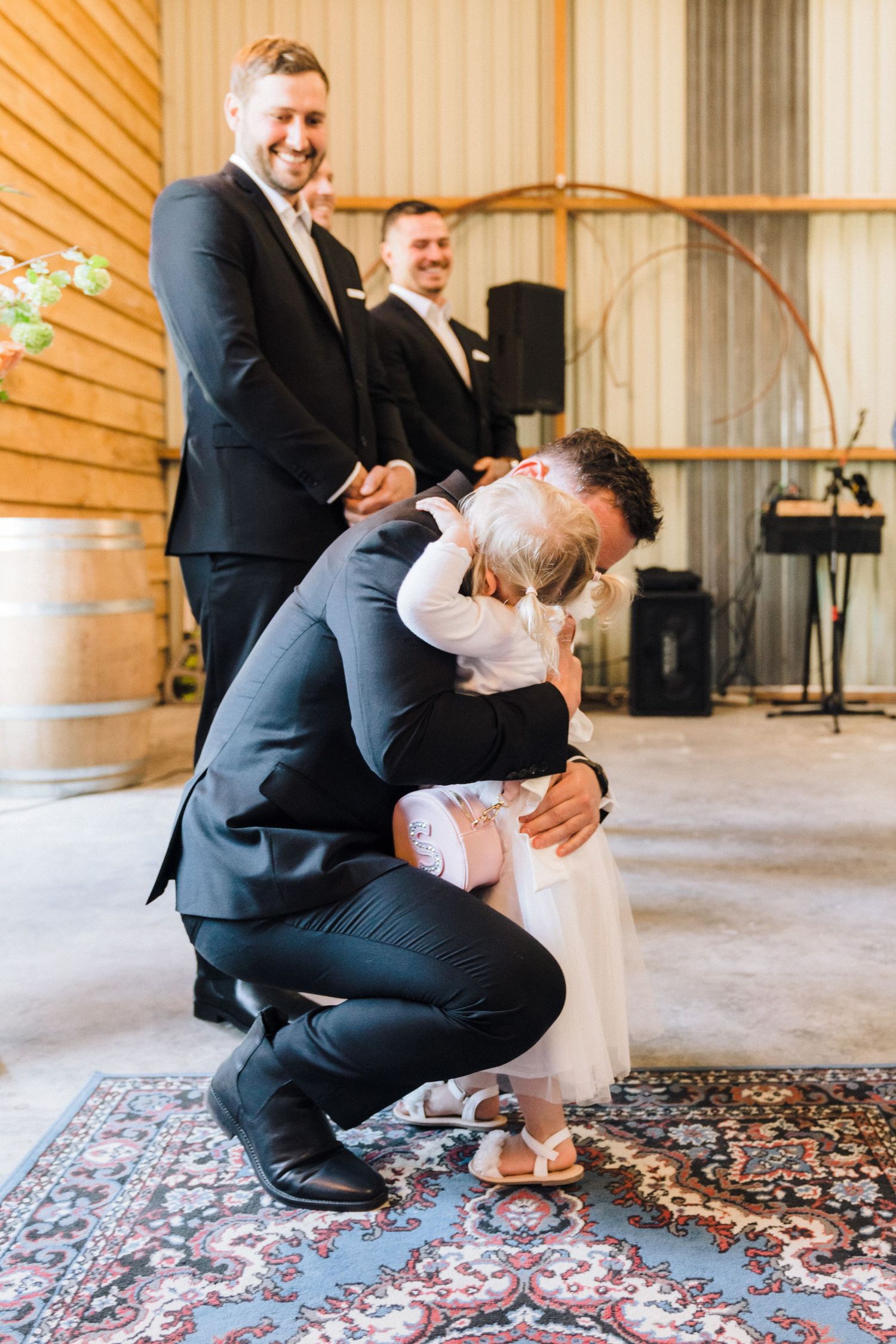 Sweet moment captured on a decorative rug during a wedding celebration.