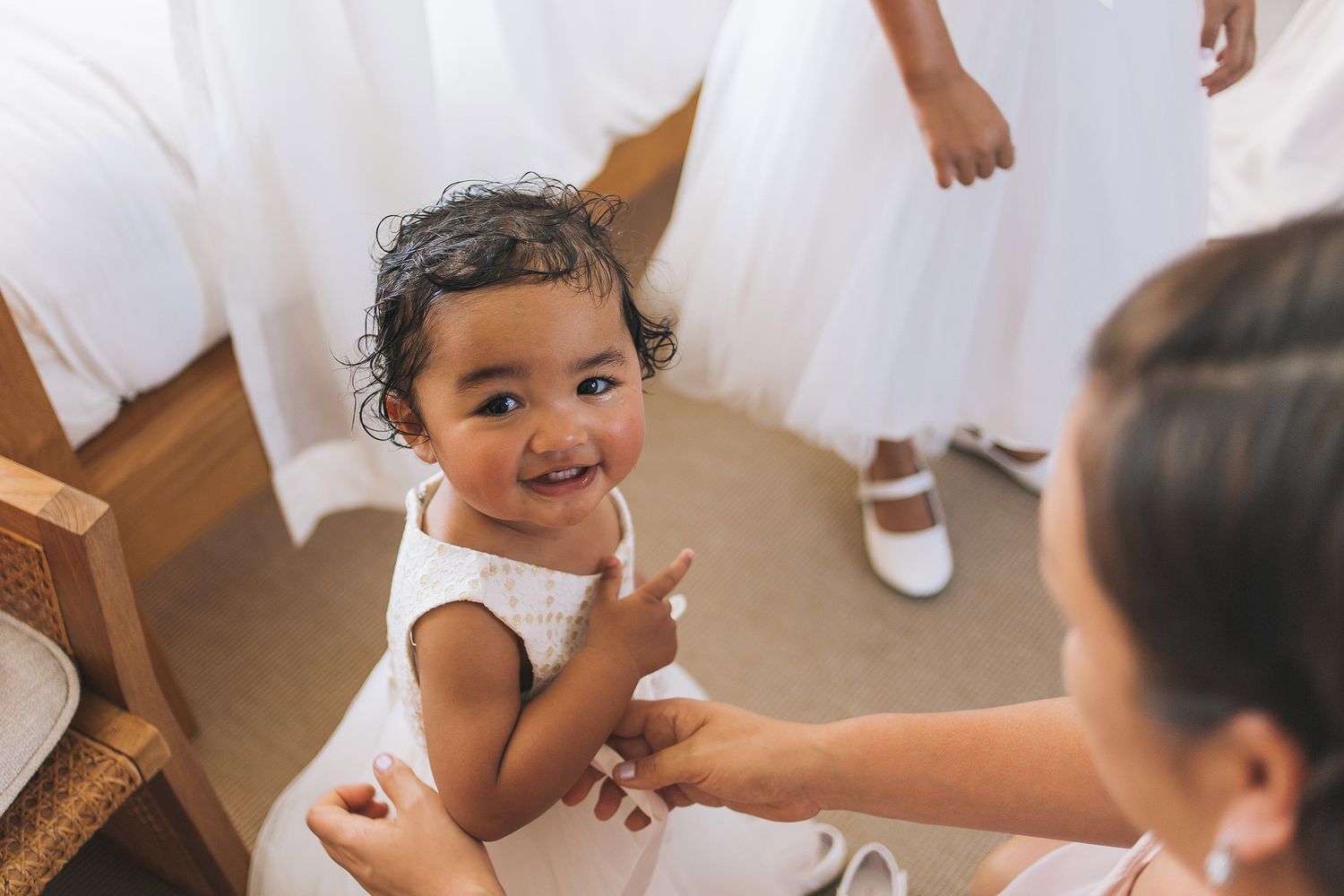 Flower girl tossing pink rose petals from a decorative basket during outdoor wedding ceremony.