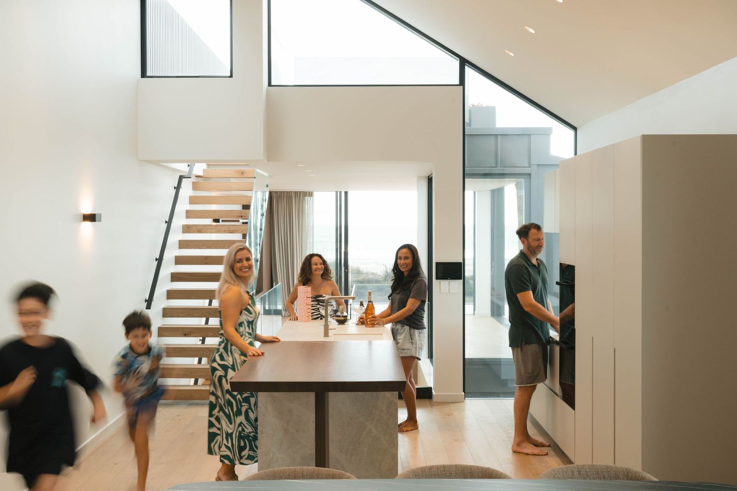 Group practicing yoga poses in modern minimalist room with large windows and natural light.