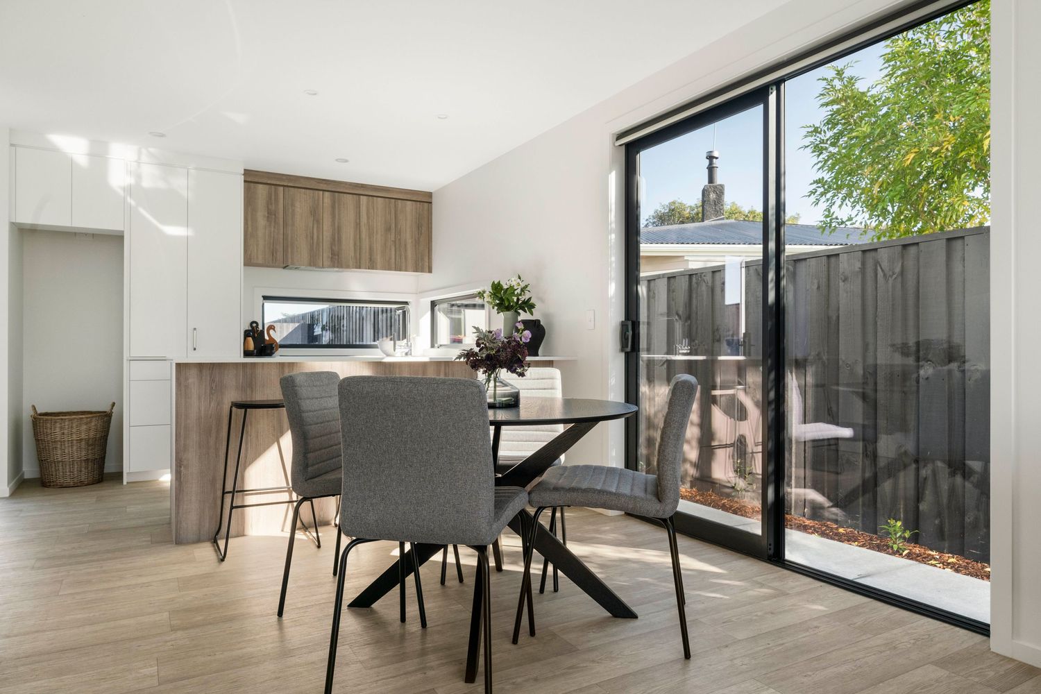 Modern living room interior features sleek bamboo flooring, minimalist furniture, and large windows for natural light.
