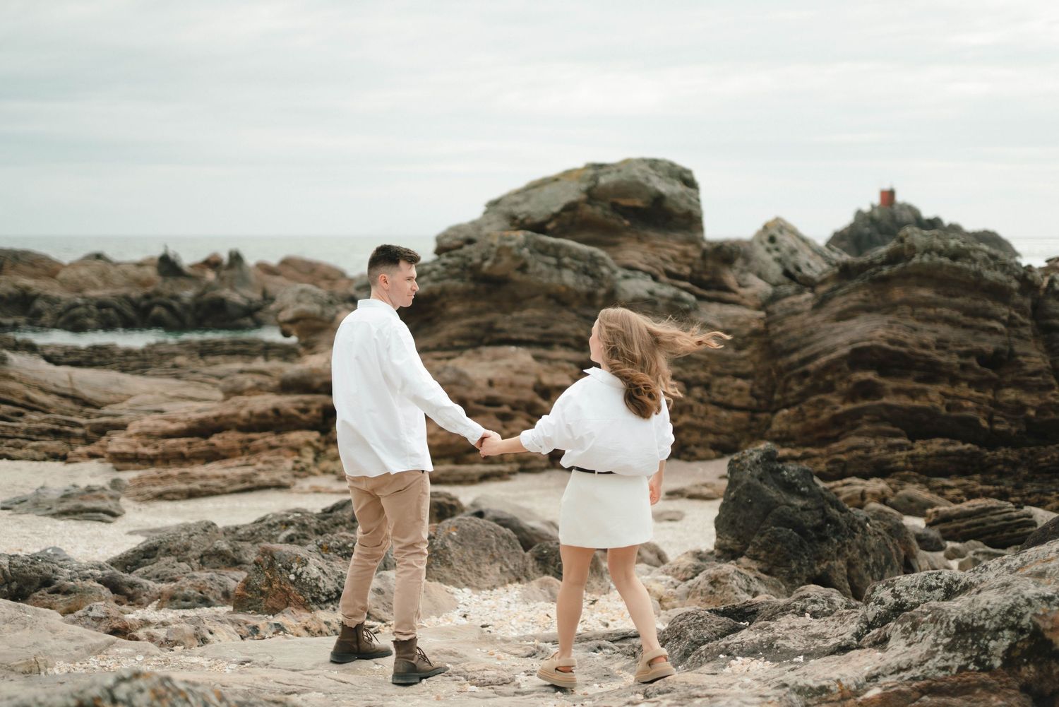 Sequence of romantic beach photos showing couple walking together on rocky coastal landscape at sunset.