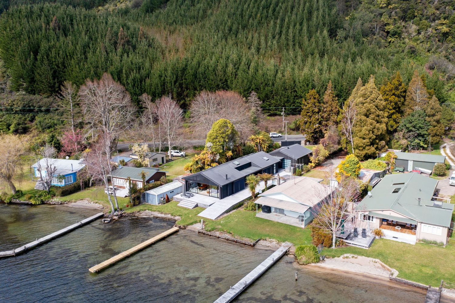 Lakefront mobile home park with private docks and autumn trees along the shoreline viewed from above.