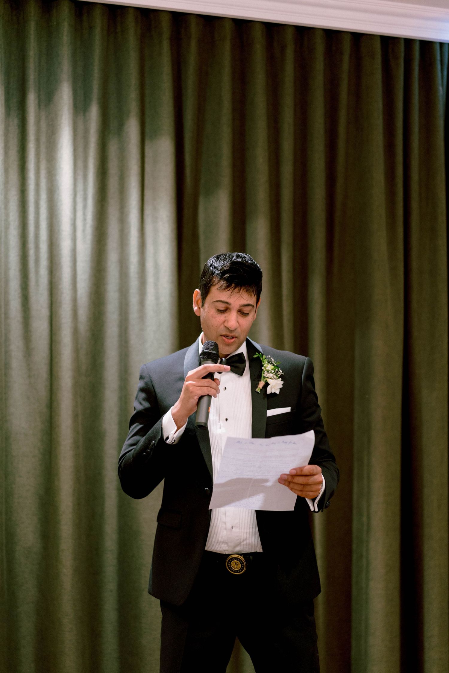 Wedding speech sequence showing emotional reactions while reading from papers at a formal event.