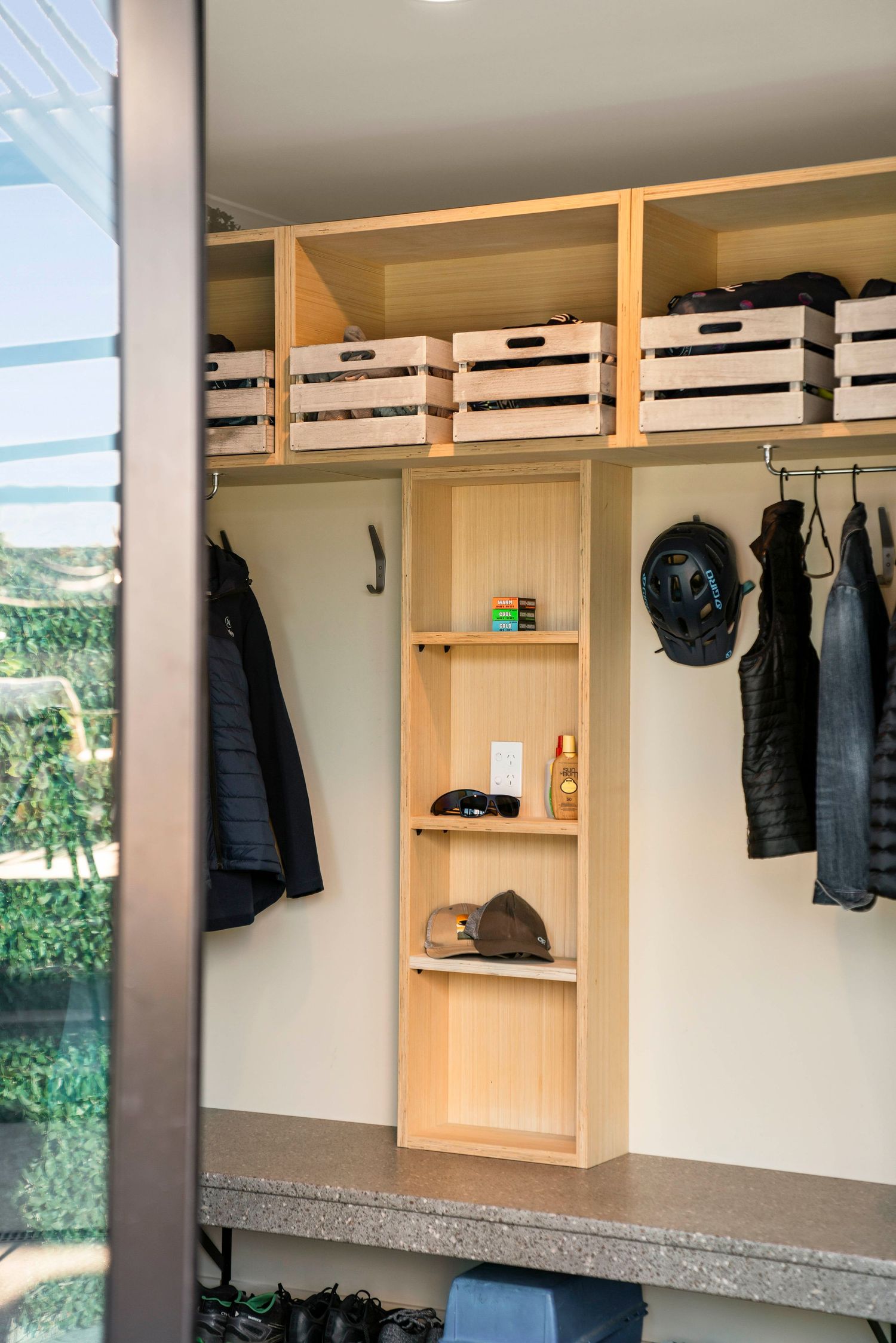 Custom built-in wooden closet organization system with hanging storage for coats and accessories.