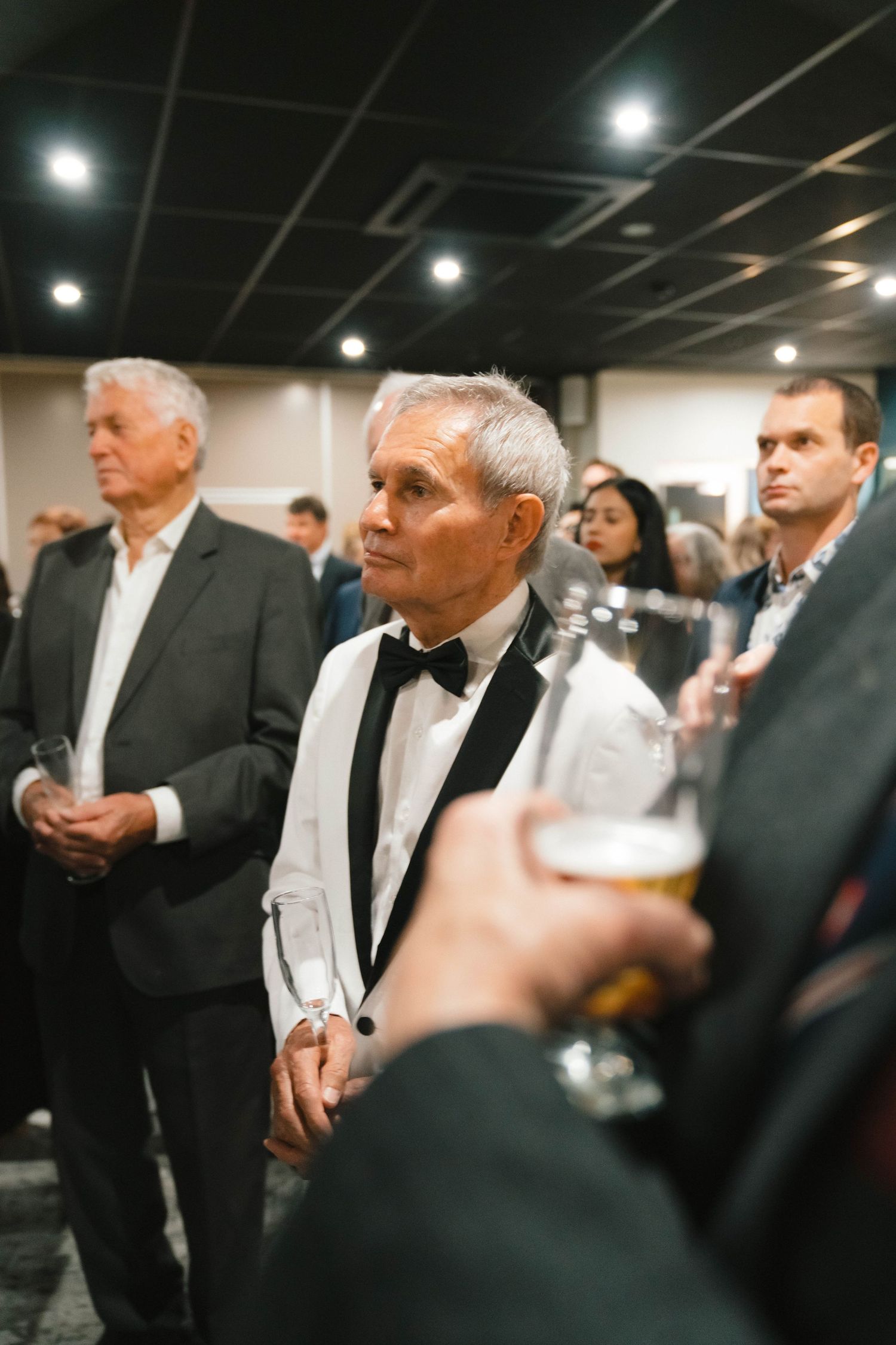 Guests in formal attire gathered for drinks at an upscale event.