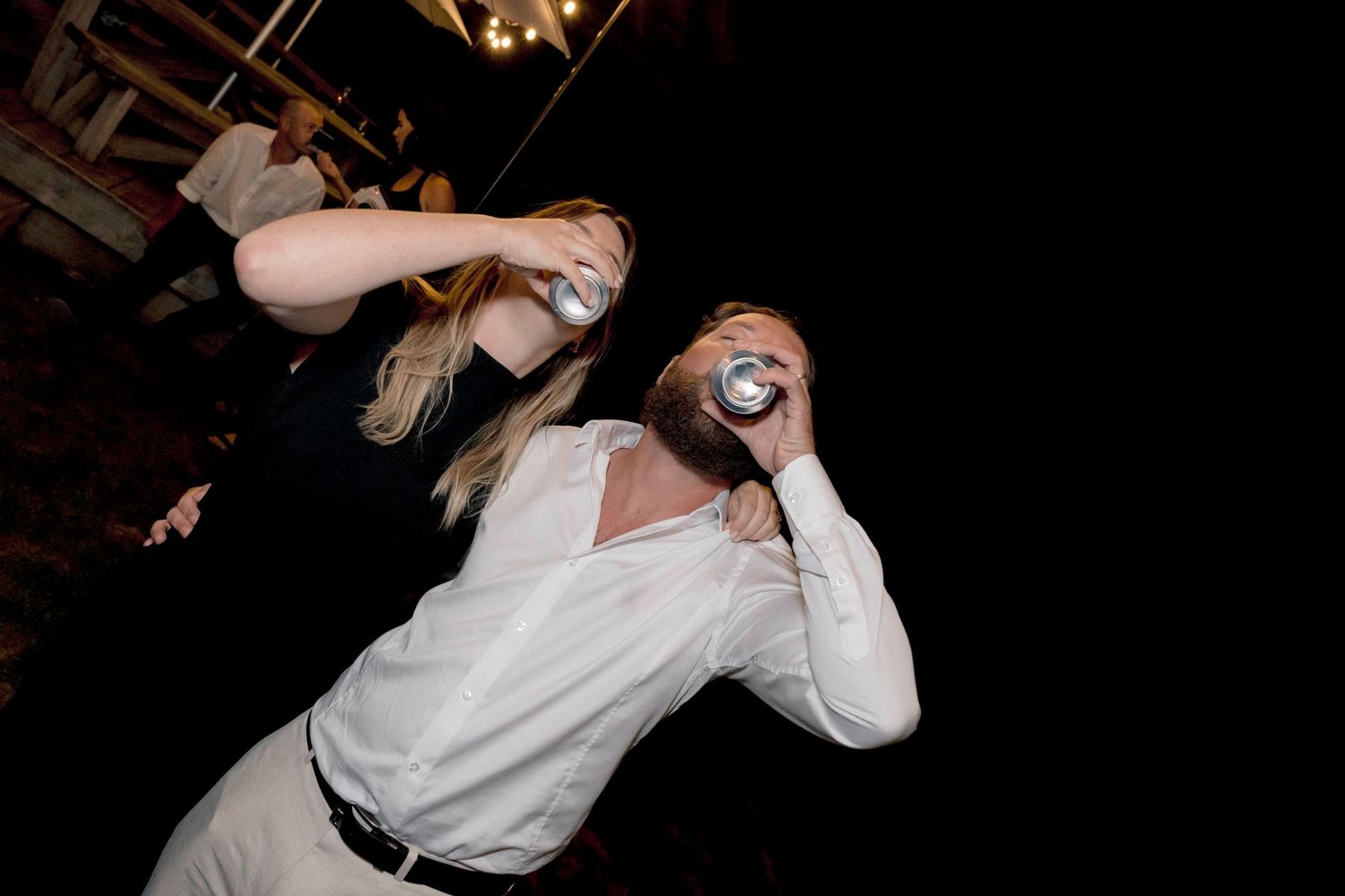 Wedding guests enjoying themselves on the dance floor at an evening reception celebration.