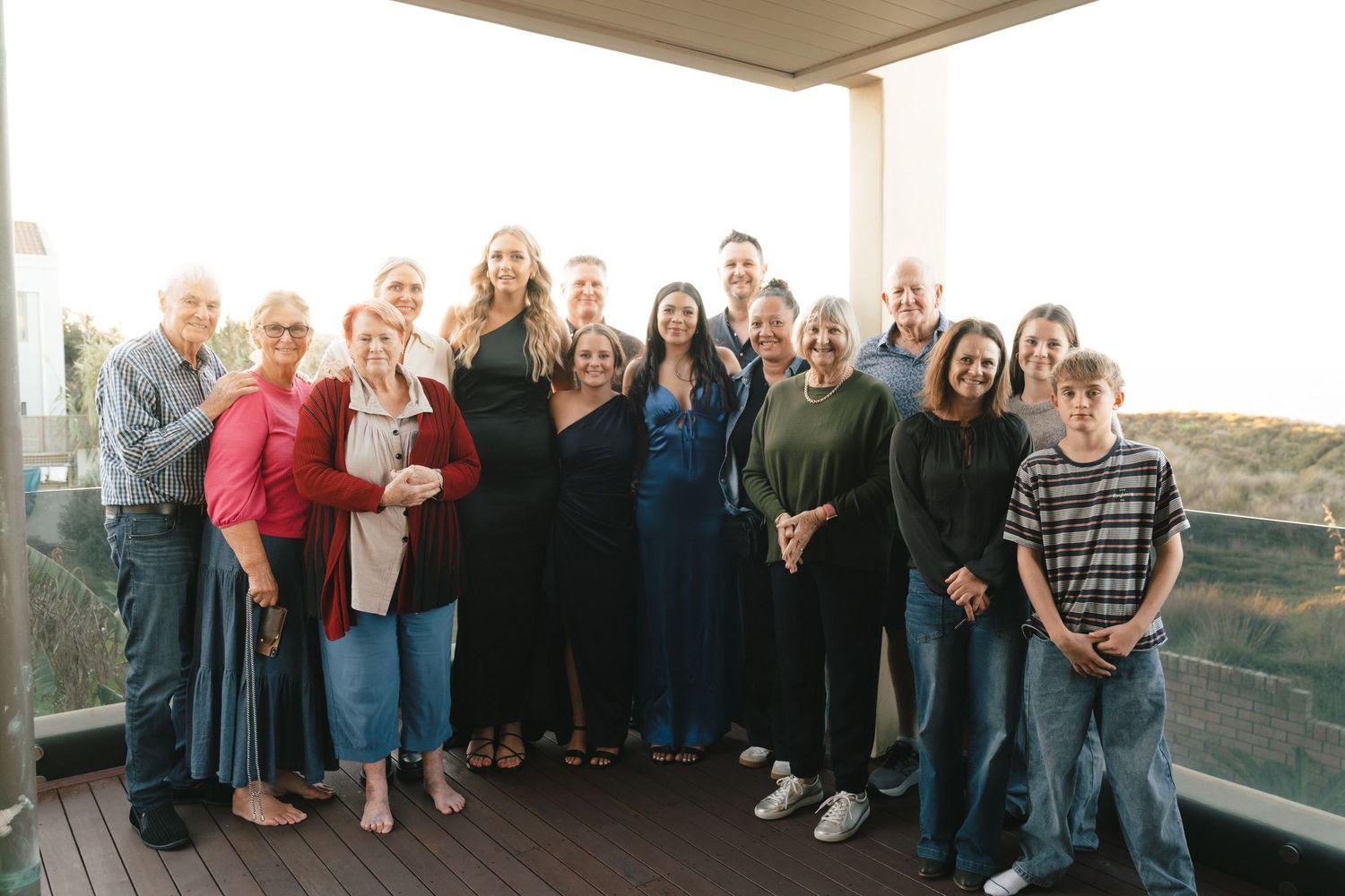 Large group gathering on covered patio with guests in mix of casual and formal attire.
