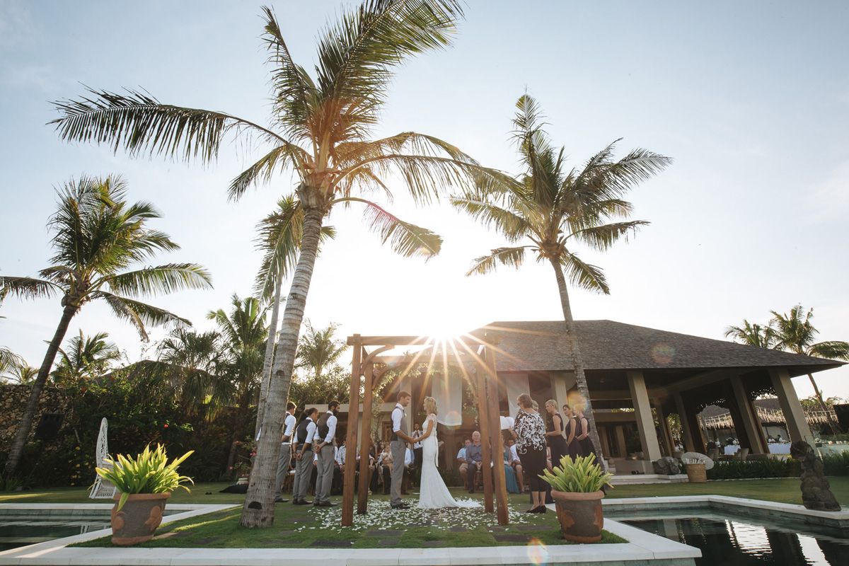 Scenic outdoor wedding venue with palm trees swaying in the breeze at golden hour in Hawaii.