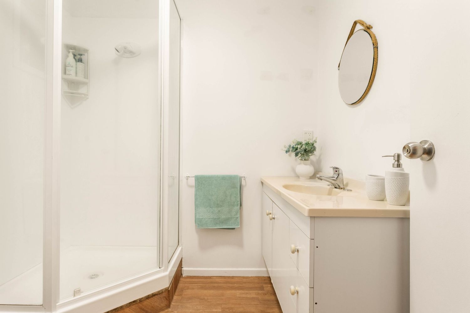 Clean white bathroom with modern fixtures, tile flooring, and natural light.