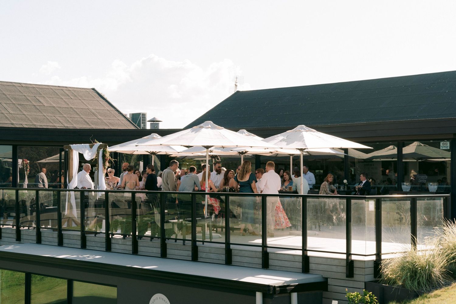 Outdoor wedding venue with multiple covered pavilions and guest seating areas.