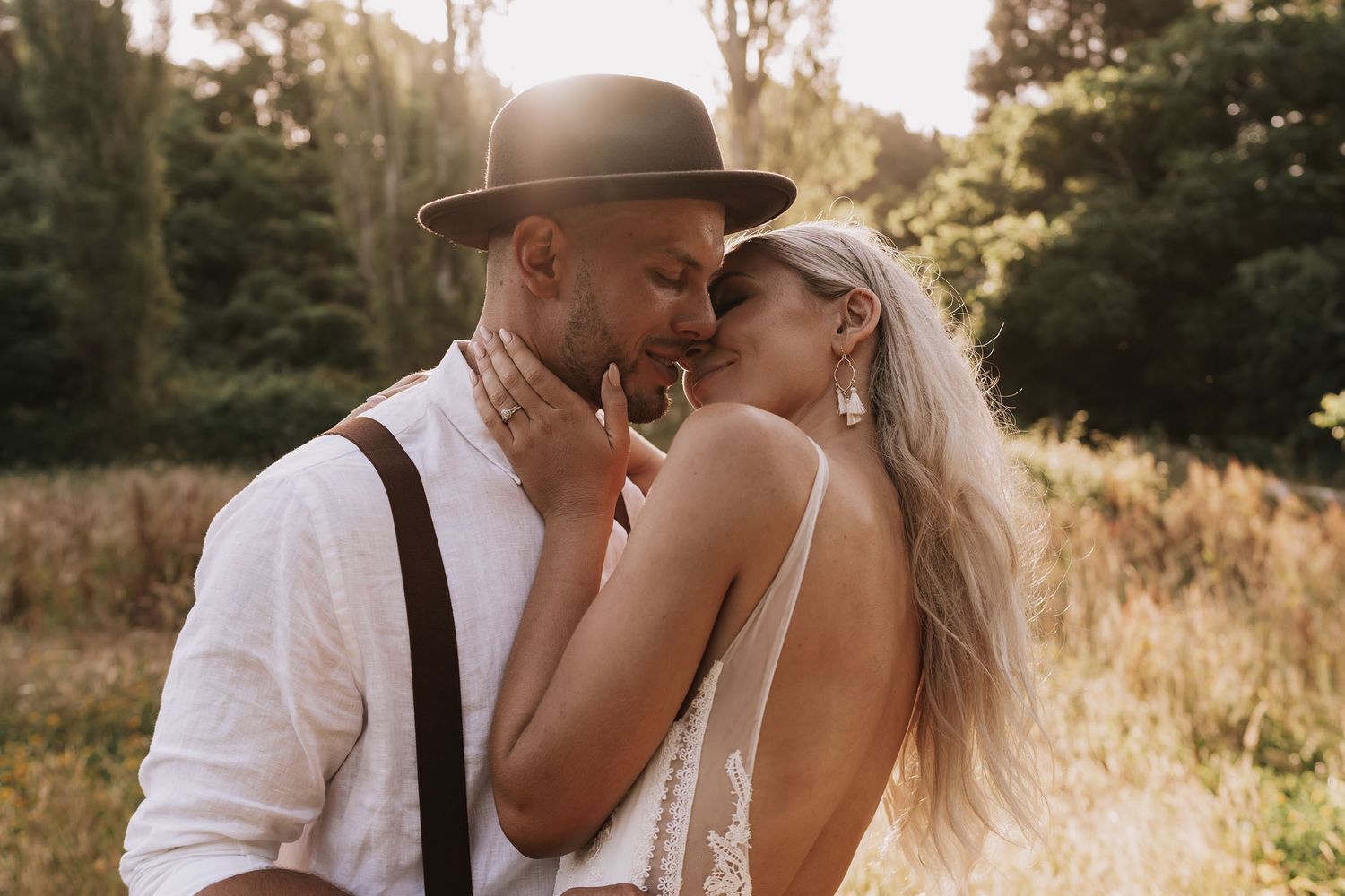 Black and white romantic portraits of couple sharing intimate moments in rural outdoor setting.