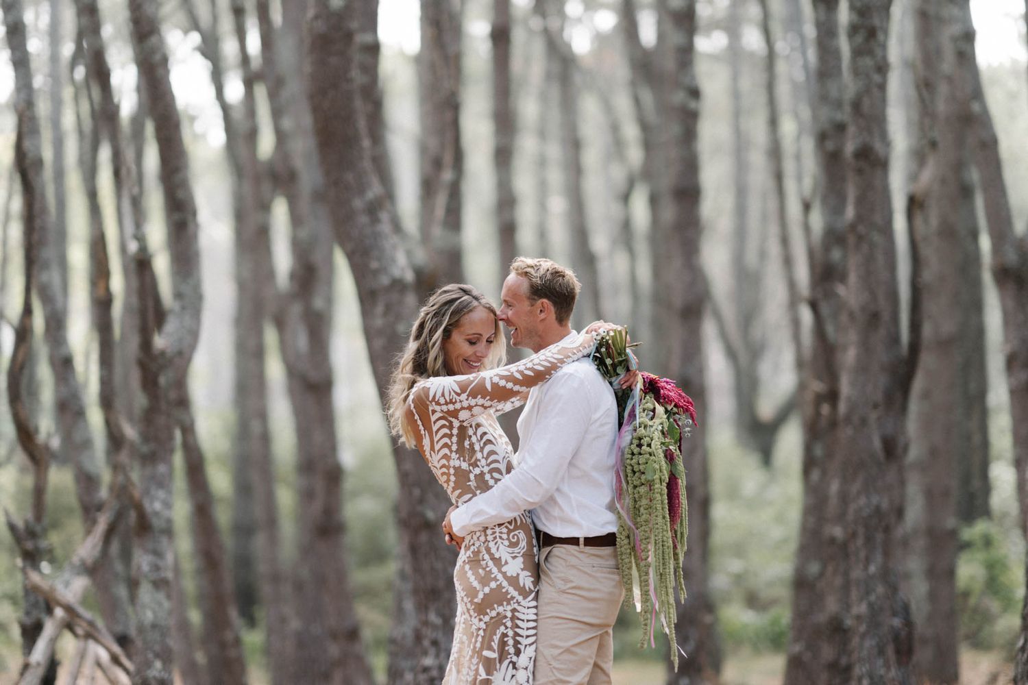 A romantic moment captured between a couple embracing in a misty eucalyptus forest.