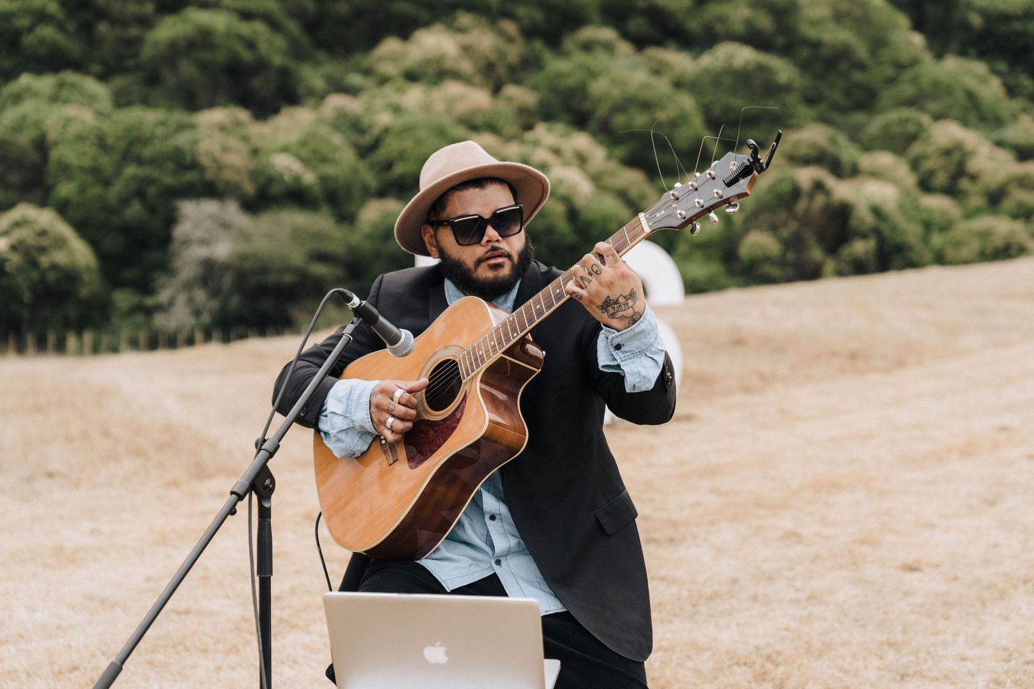 Musicians perform live acoustic music at an outdoor wedding ceremony.