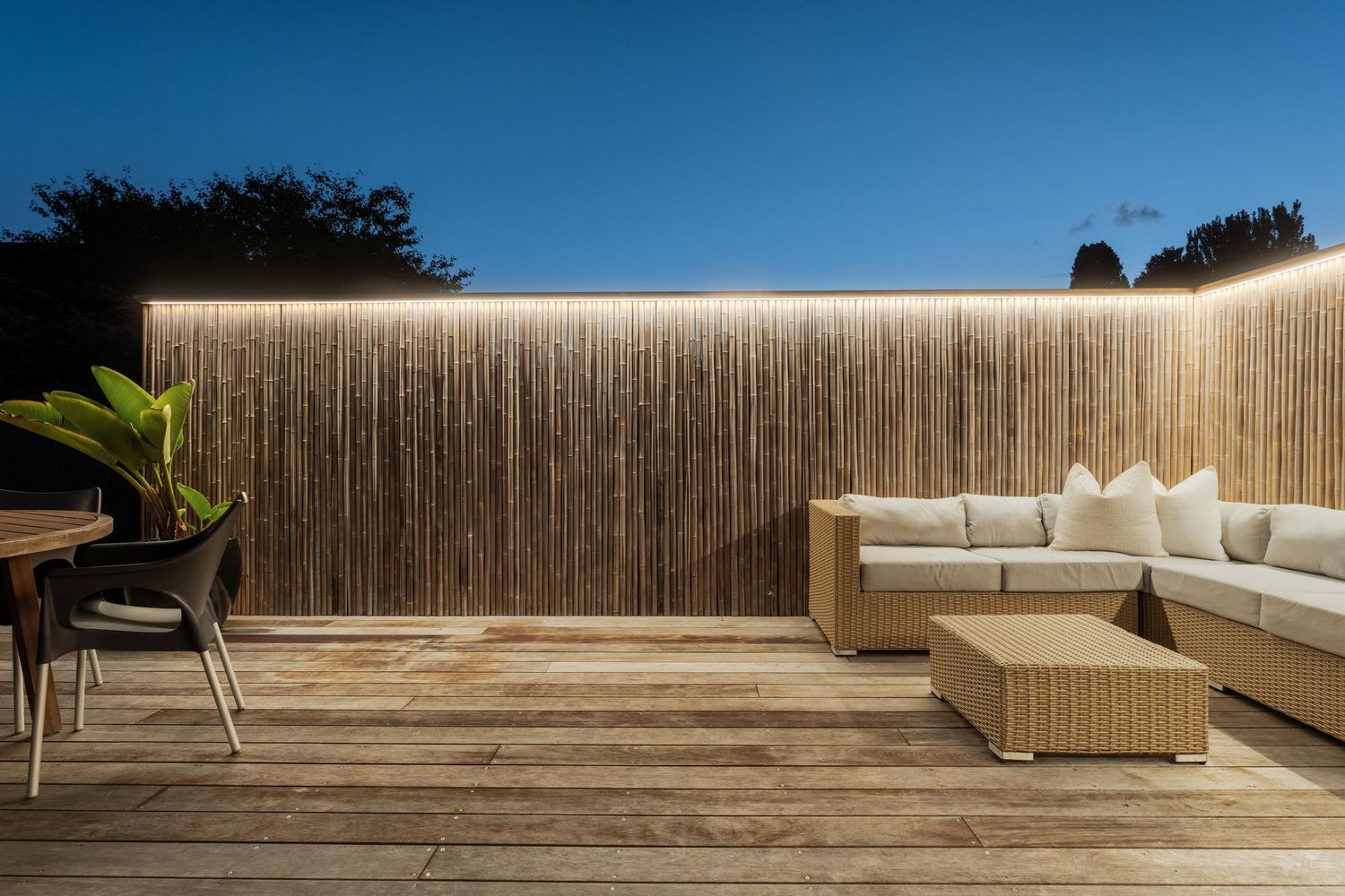 Modern rooftop deck with bamboo privacy screens and comfortable outdoor seating.
