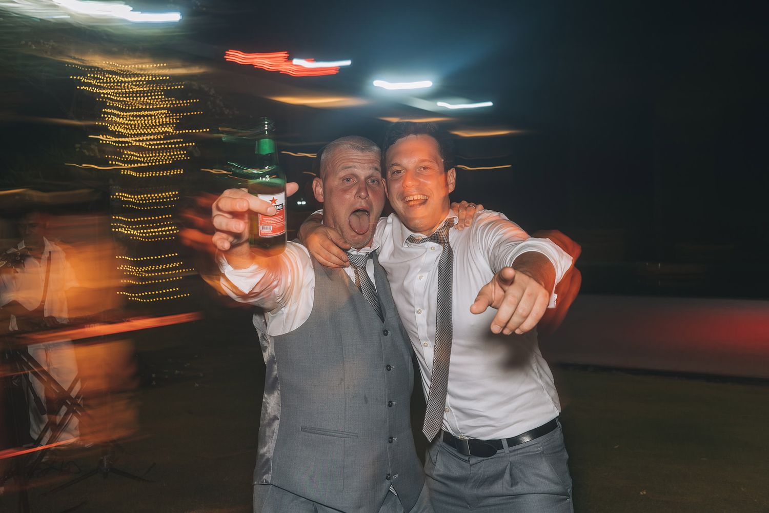 Wedding guests celebrating and dancing at evening reception.