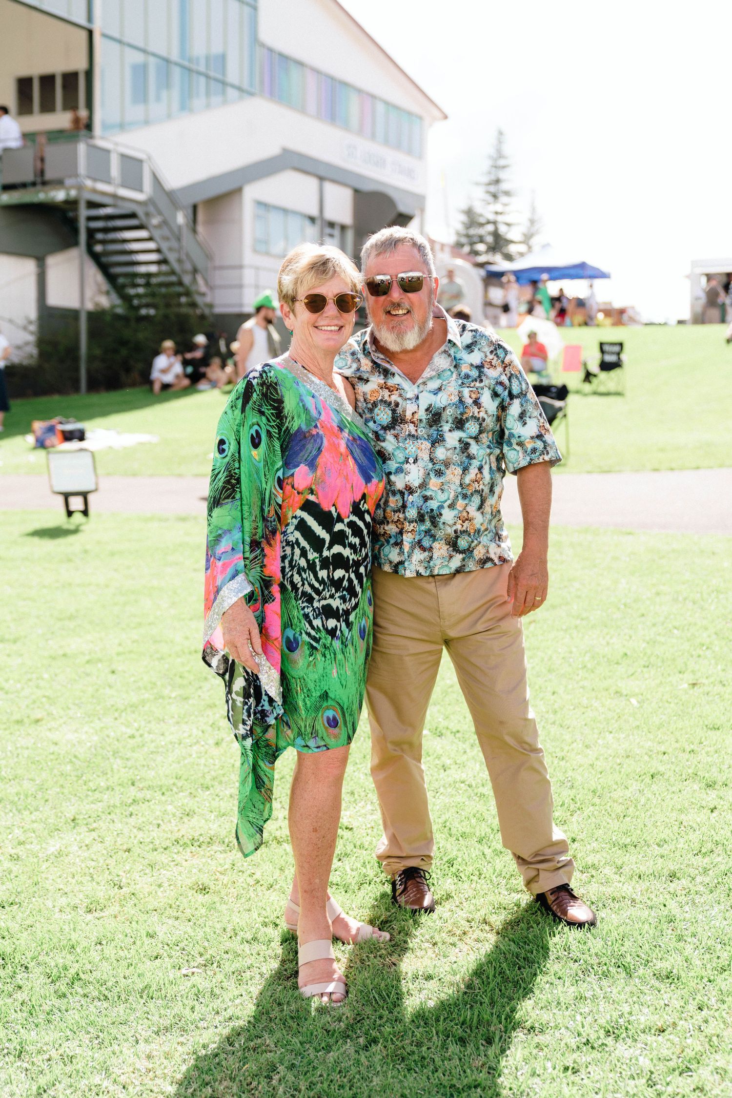 Attendees in tropical prints and summer wear enjoying a sunny outdoor gathering.