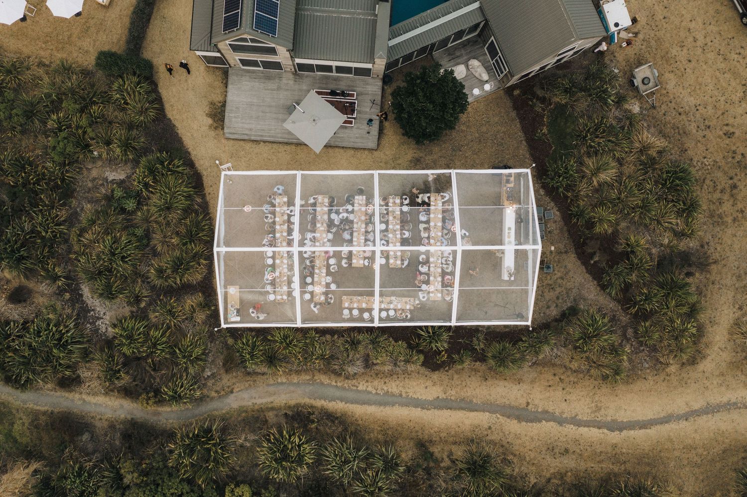 Aerial drone view of architectural floor plan overlay on building structure surrounded by natural landscape.