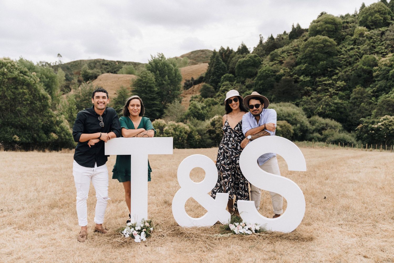 Large white I & S letters displayed in a rustic outdoor setting with rolling hills.