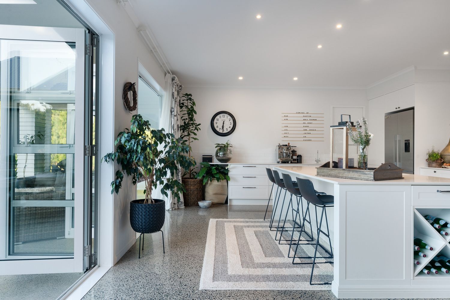 Bright contemporary kitchen with polished concrete floors and geometric pattern featuring bar seating.
