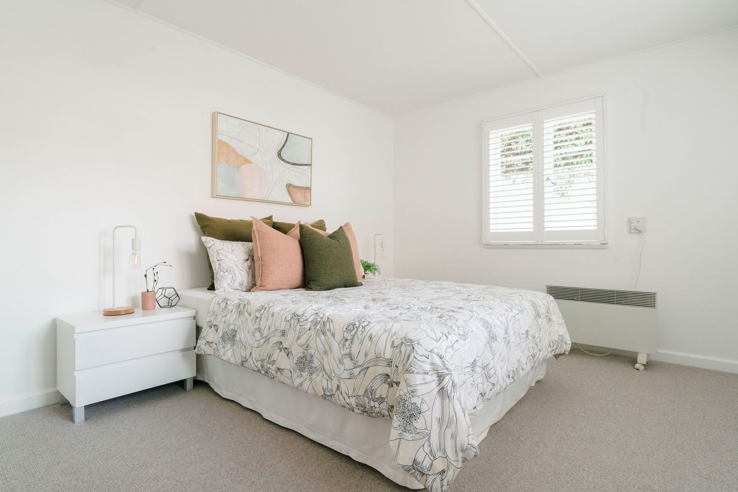 Serene bedroom with white bedding, neutral decor, and soft natural lighting.