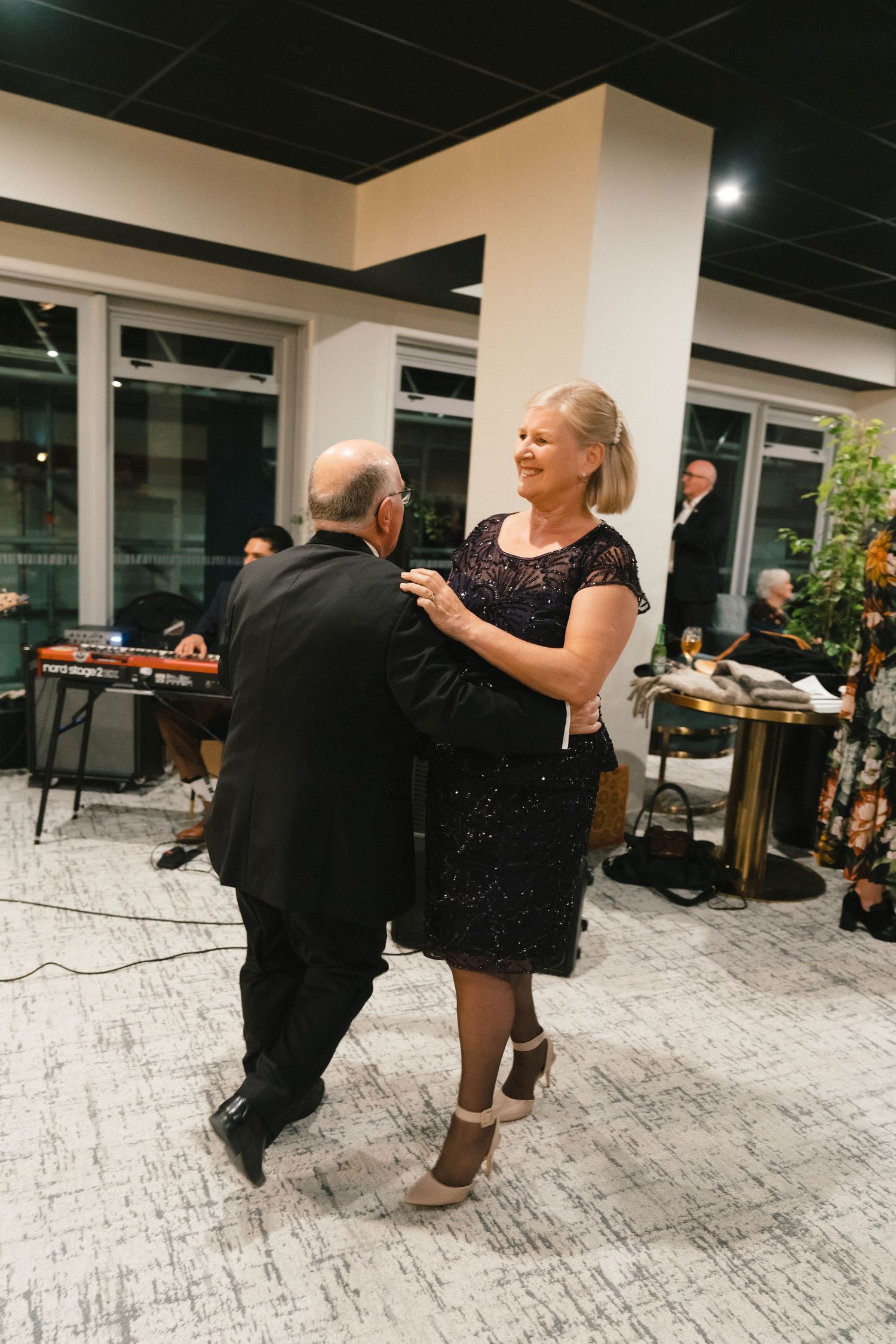 People dancing on a tiled floor at an indoor social event.
