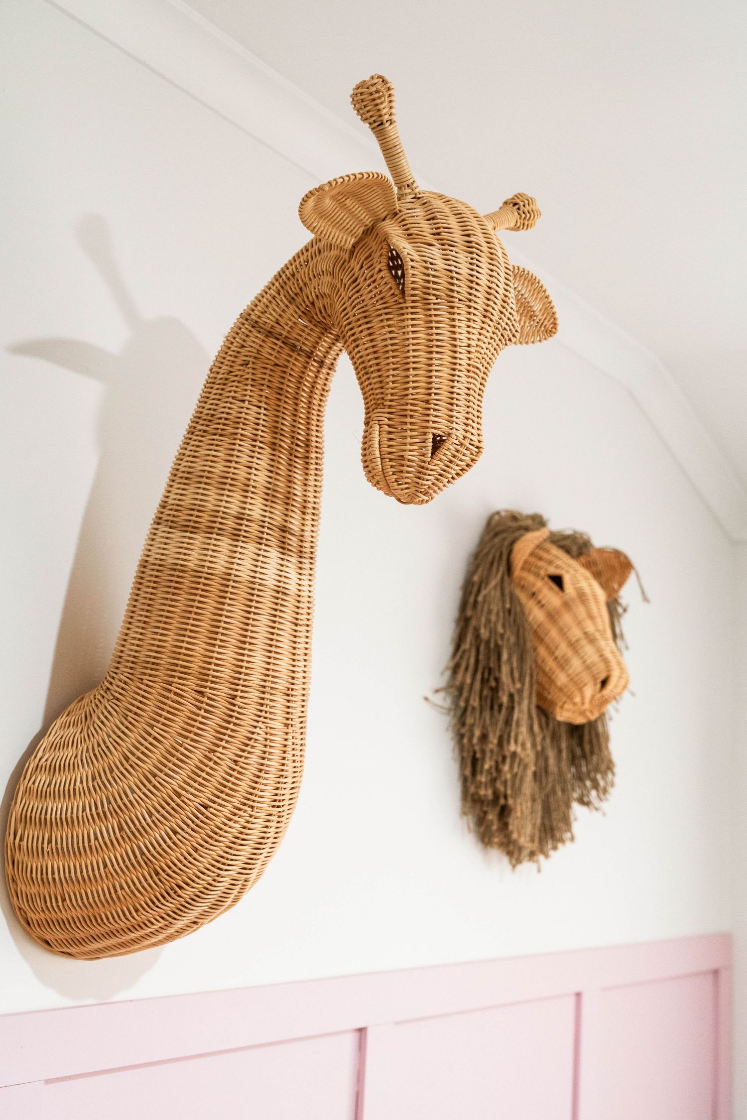 Decorative woven wicker whale wall sculpture with tan yarn details designed for coastal home decor.