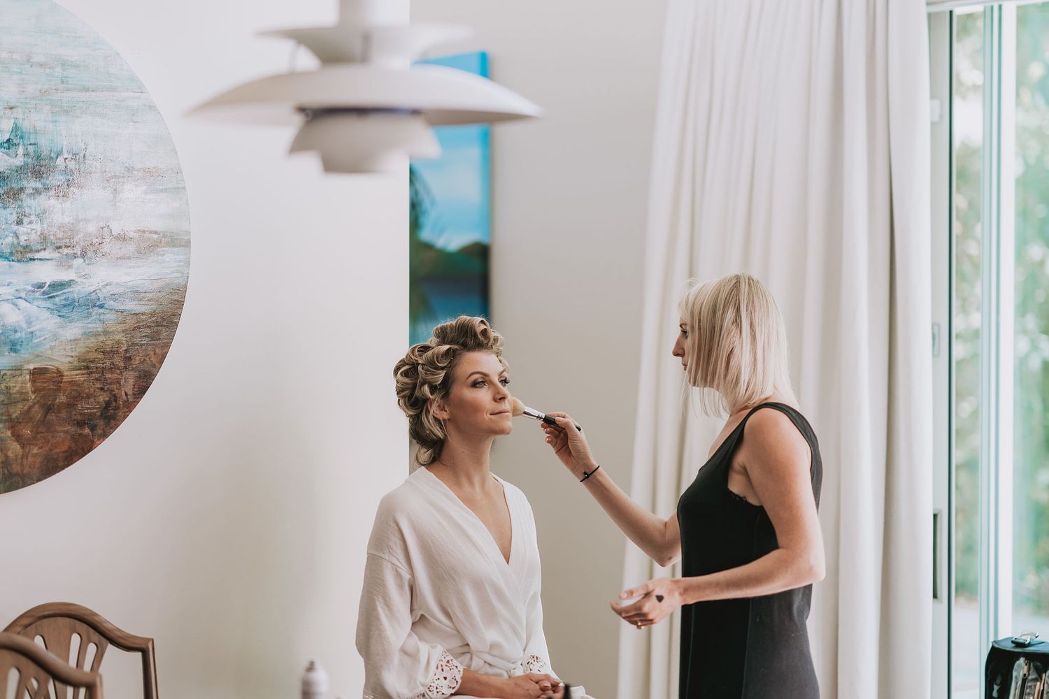 Hair salon professional applying styling products and accessories to client during a beauty service session.