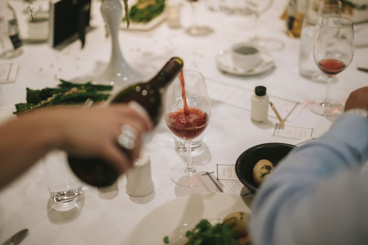 Several wine glasses on a white tablecloth during an elegant dinner party or restaurant setting.