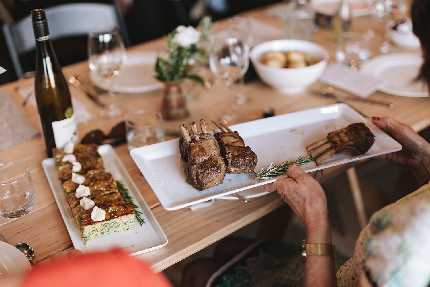 Elegant table settings at a fine dining restaurant with wine glasses, plates, and rustic wooden details.