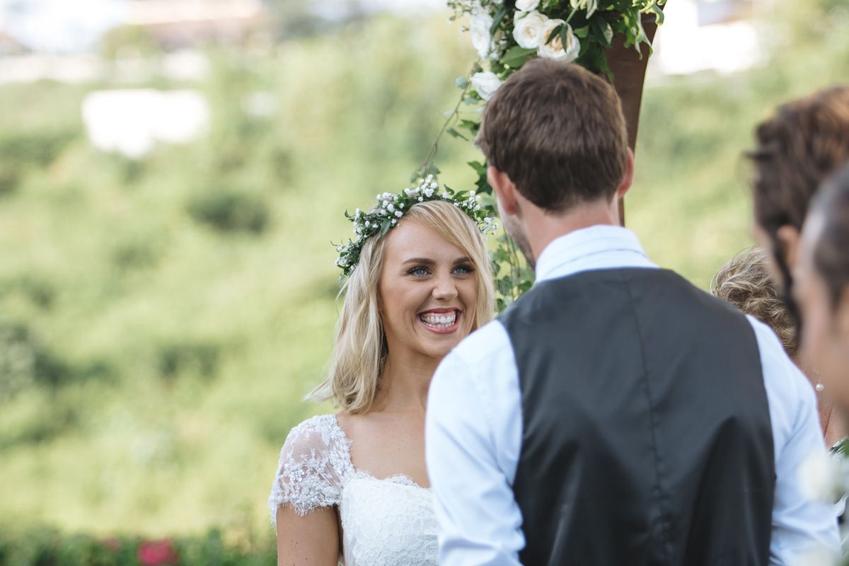 Intimate outdoor wedding ceremony moment with lush greenery in the background.