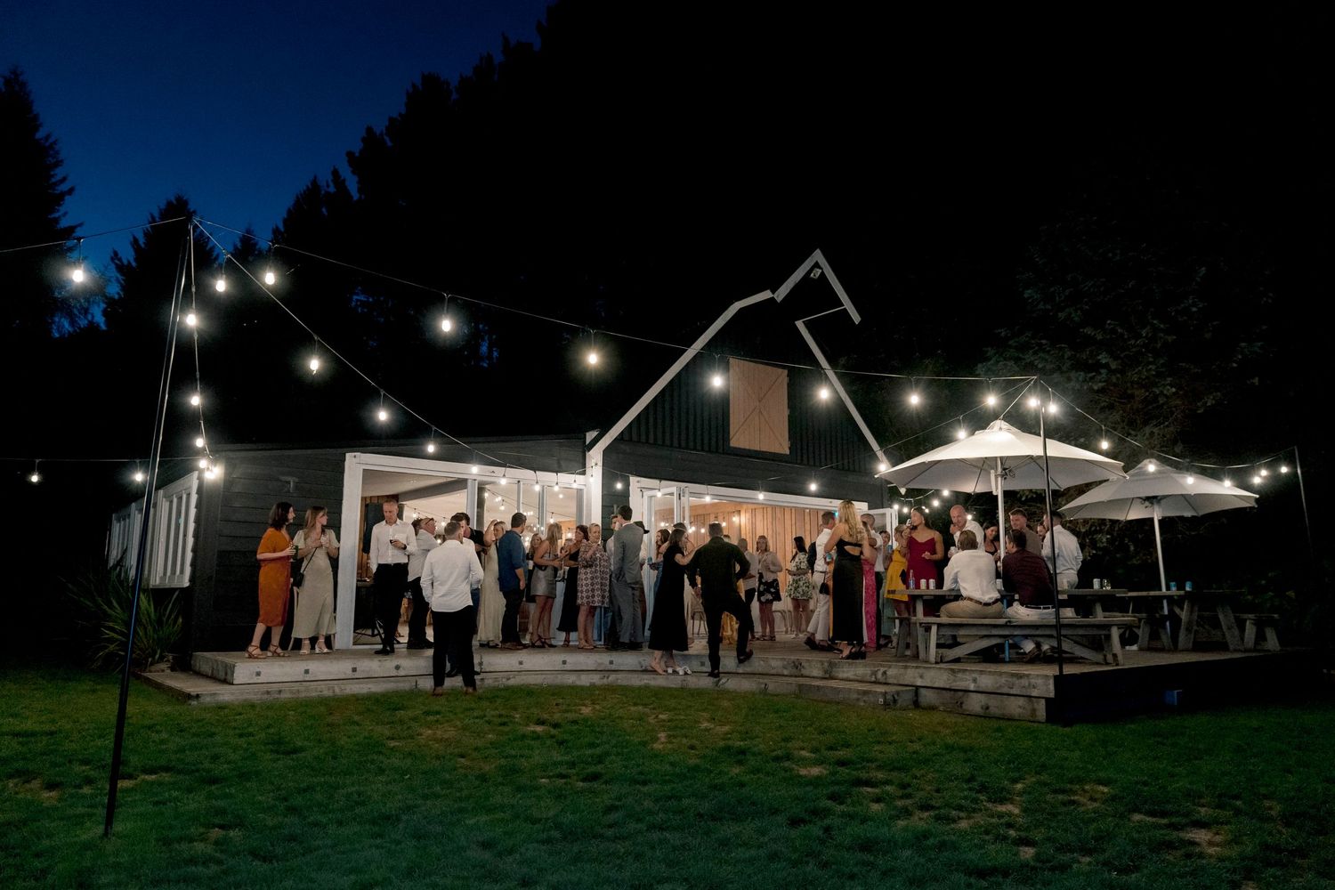 Wedding reception at rustic venue with string lights creating evening ambiance.