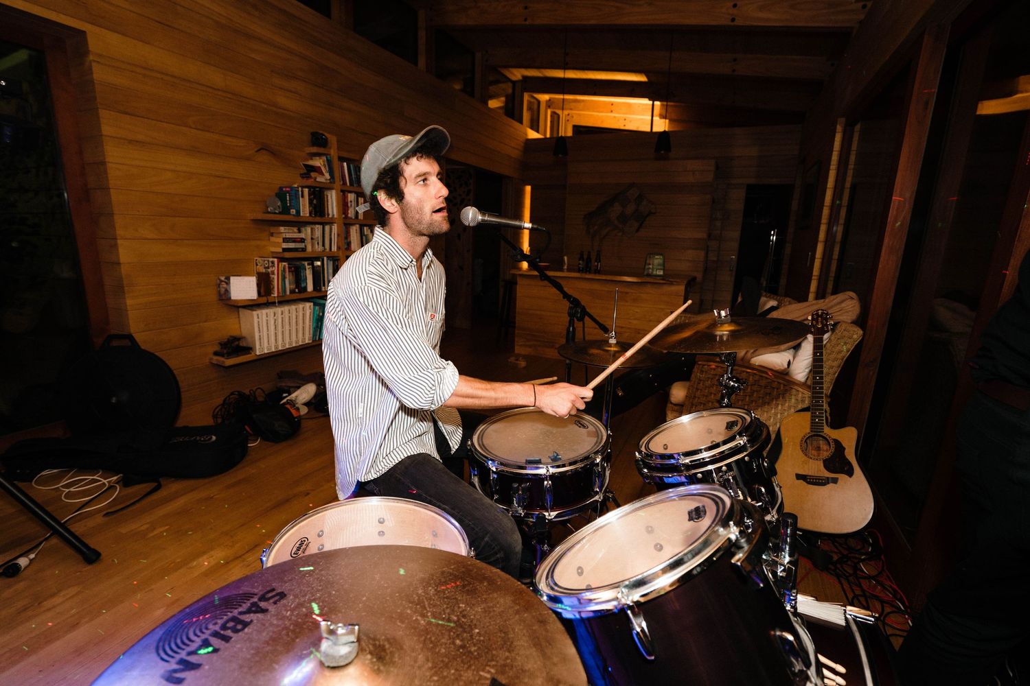 A drummer performs at a dimly lit wedding reception venue.