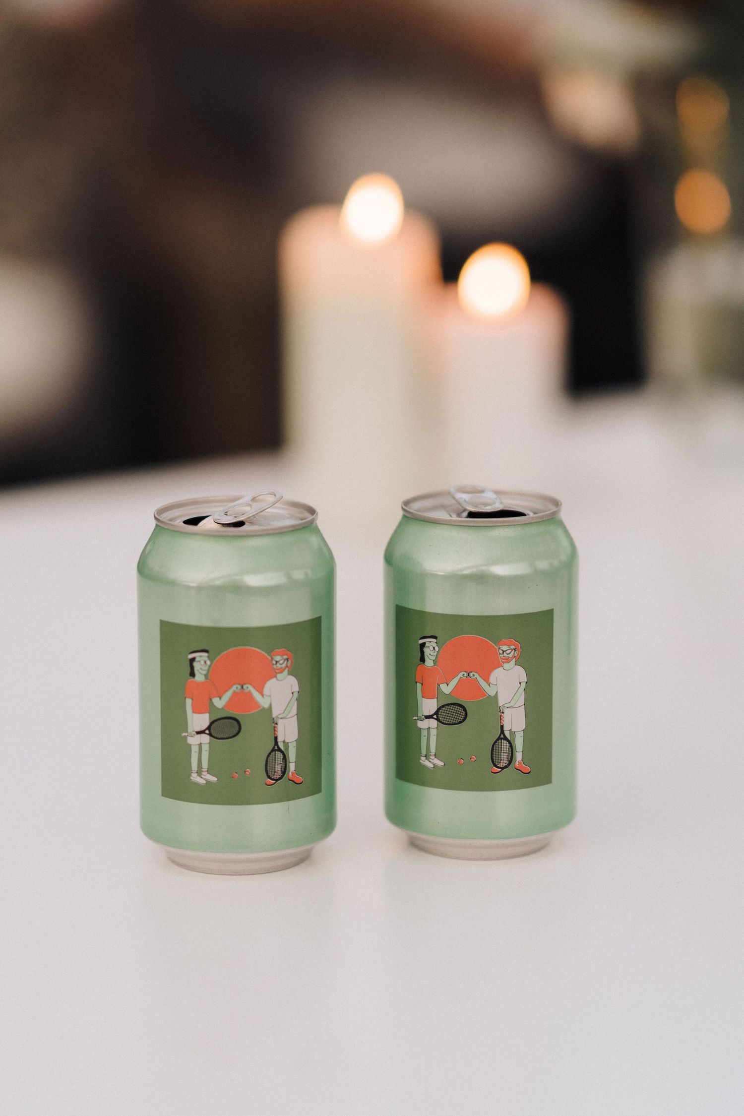 Row of green beverage cans with minimal animal graphics displayed on white surface.