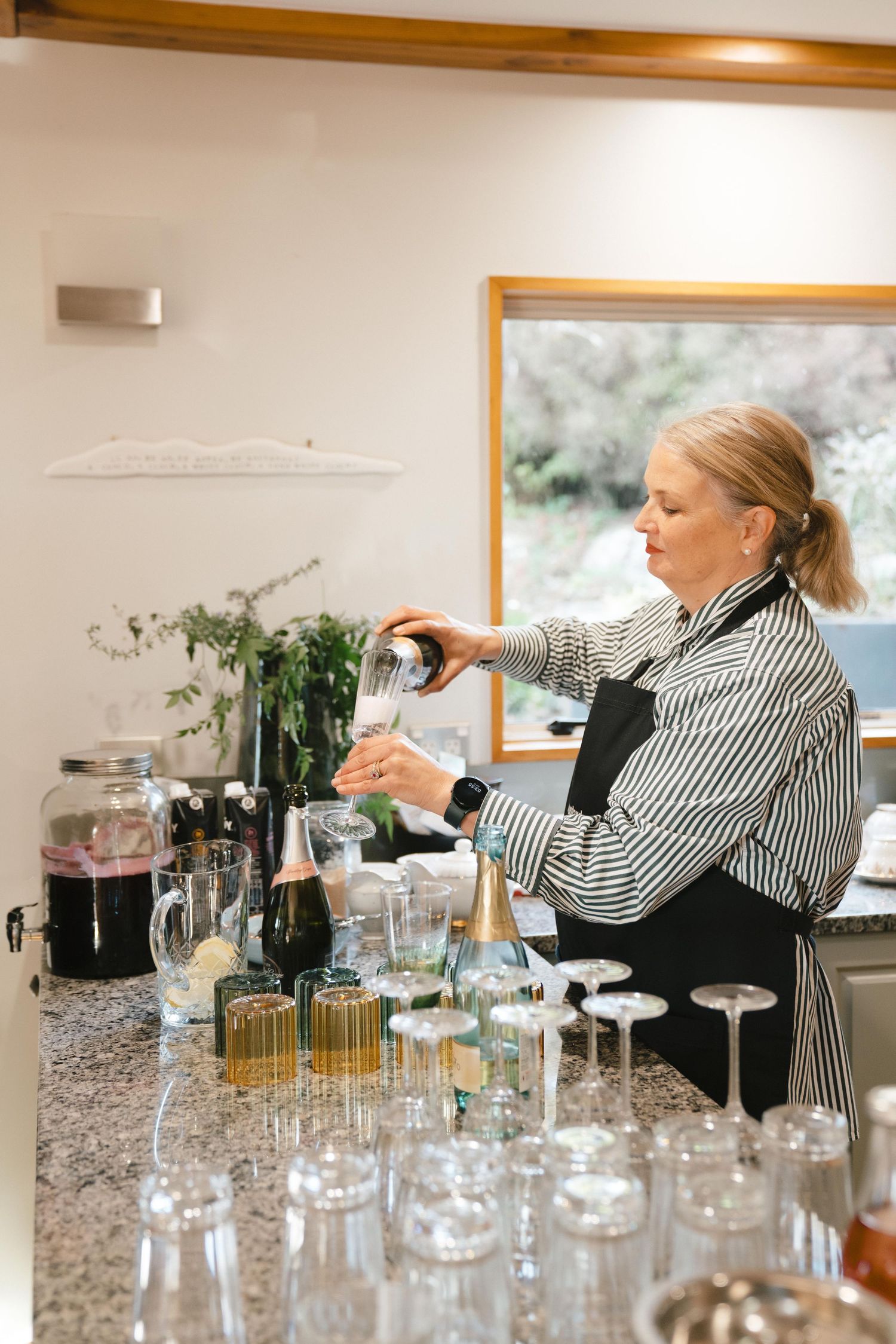 A drink service station setup with multiple glass containers and bottles being prepared.