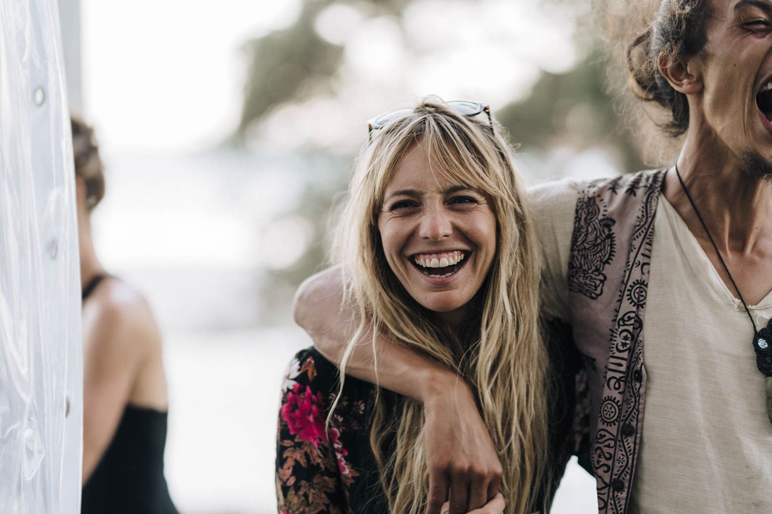 A joyful candid moment captured at an outdoor celebration with people laughing together.