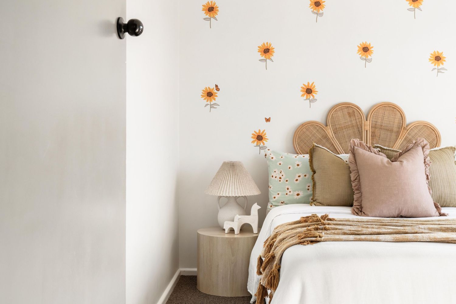 Floral wall decals accent a cozy bedroom with neutral tones and decorative pillows.