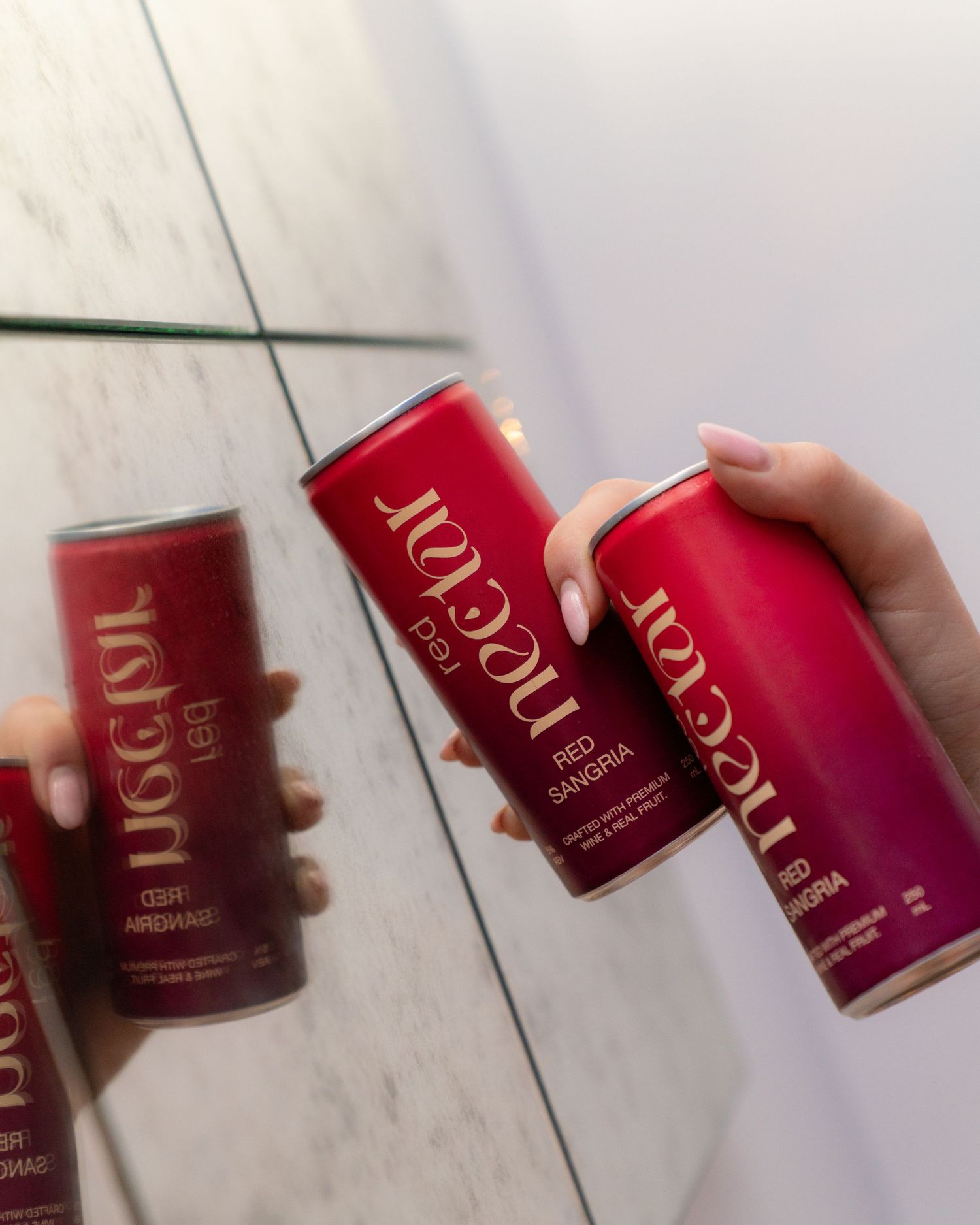 A sequence of pink Nectar cans arranged on a white floor in a dynamic layout.
