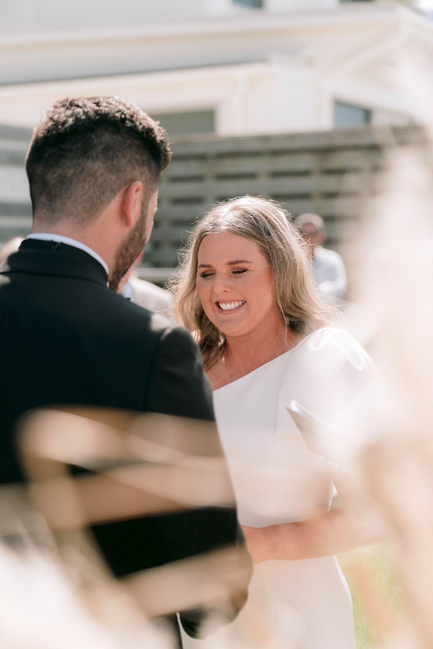 Wedding couple sharing intimate laughing moment during their outdoor ceremony.
