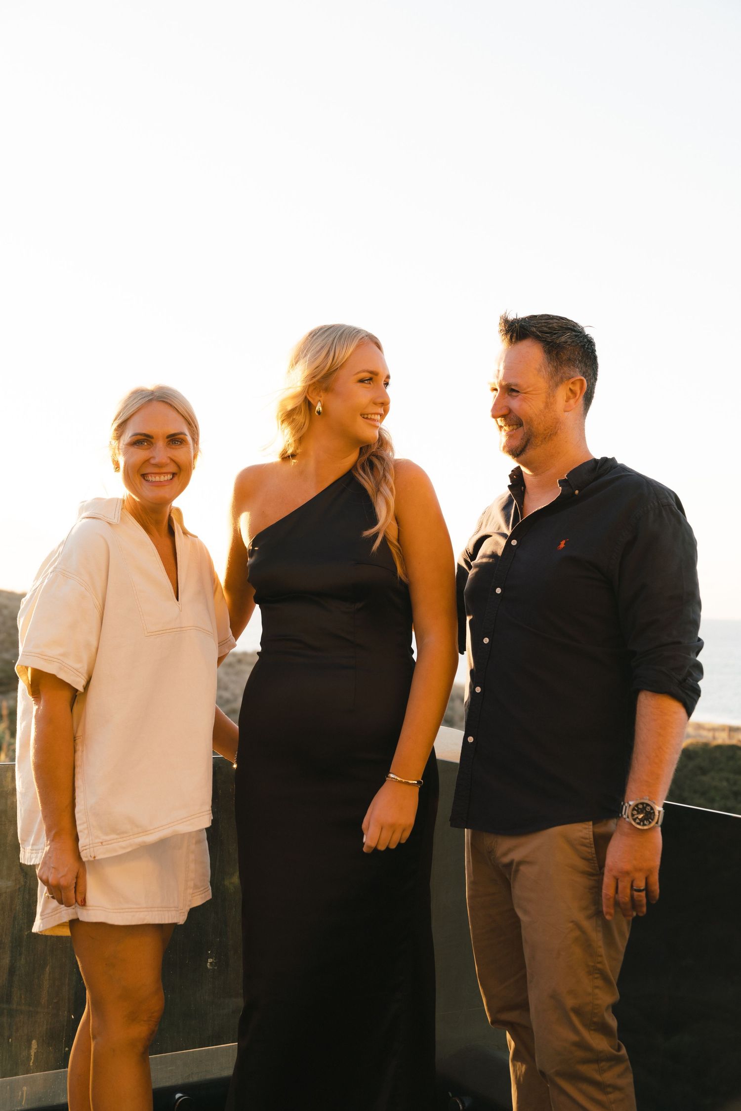 Candid group shots on outdoor deck during sunset wearing mix of casual and formal clothes.