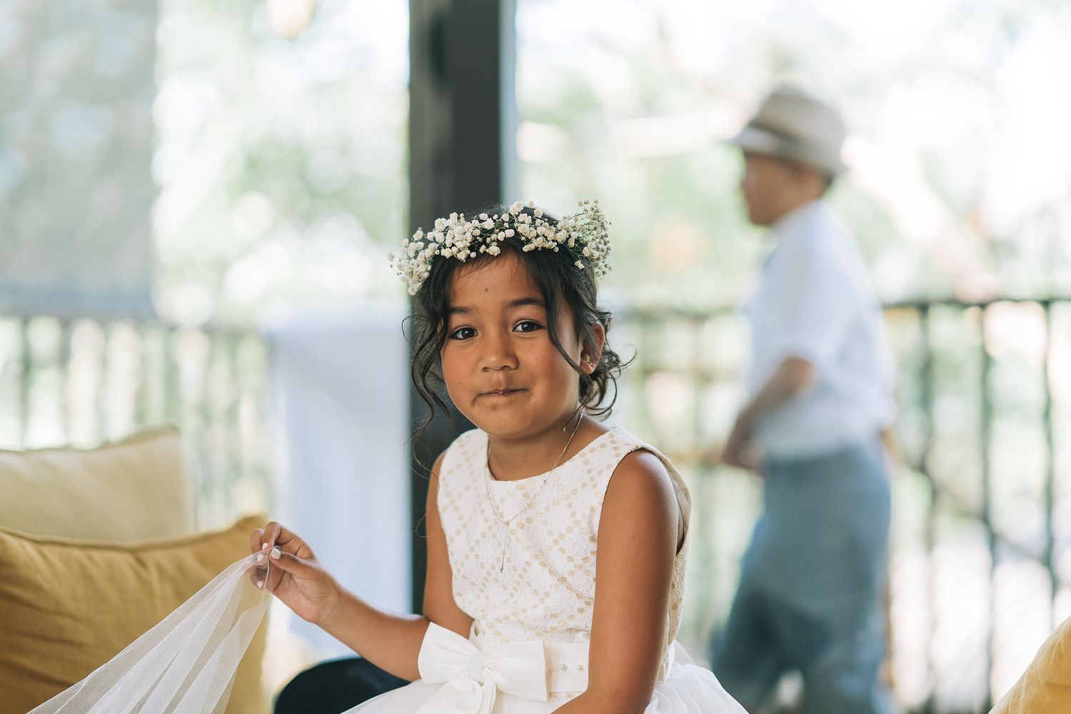 A beautiful bride walks down a tropical outdoor pathway during an elegant beachside wedding ceremony.