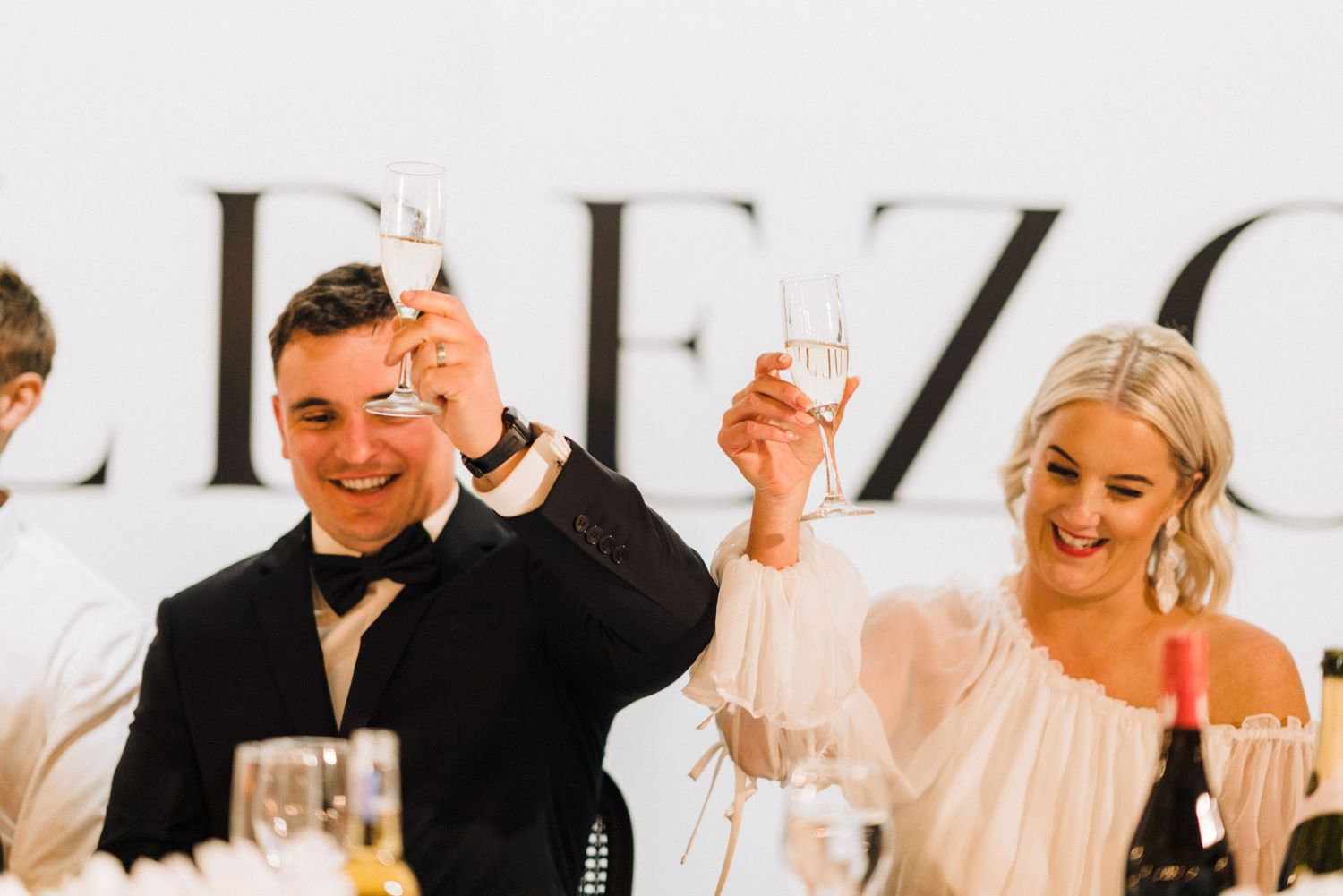 A couple raises their glasses in celebration during their wedding reception.