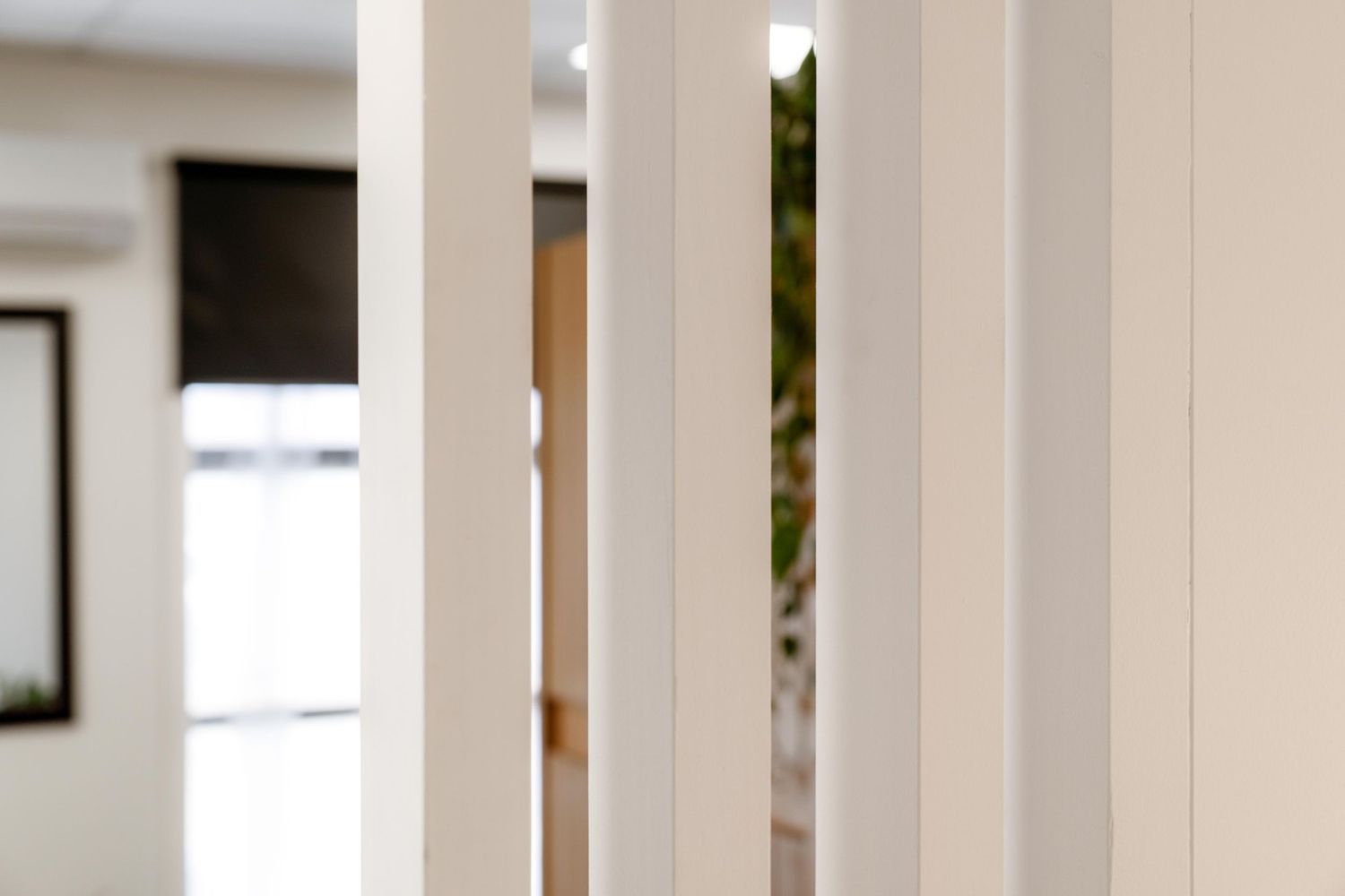Clean white interior hallway with modern architectural columns.