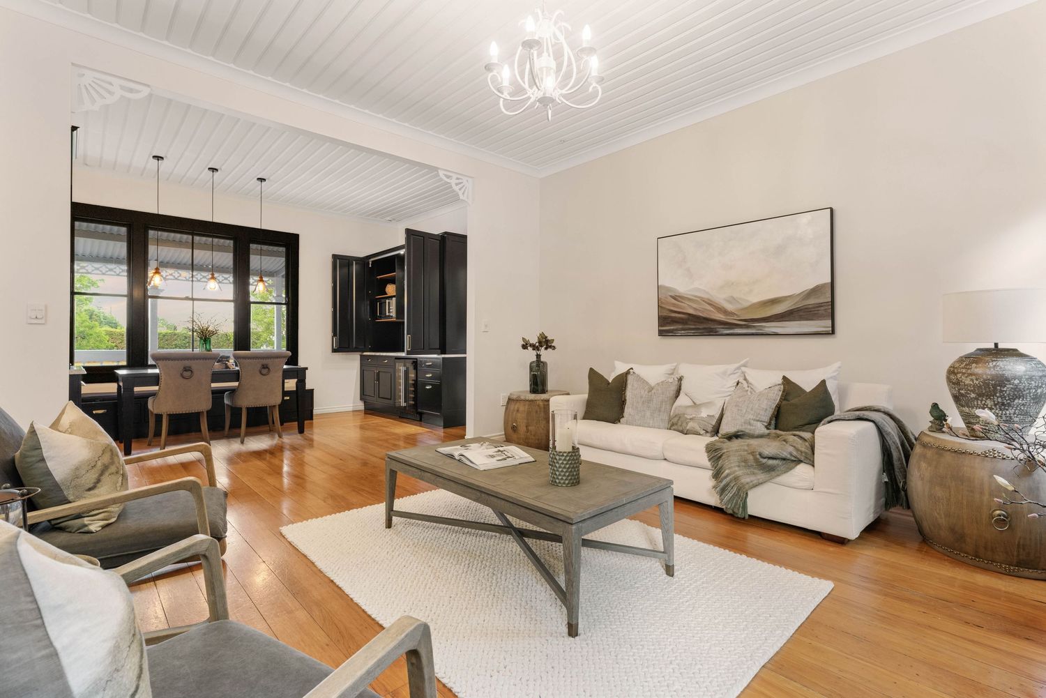 Contemporary open-concept living space with hardwood floors and modern furnishings in natural light.