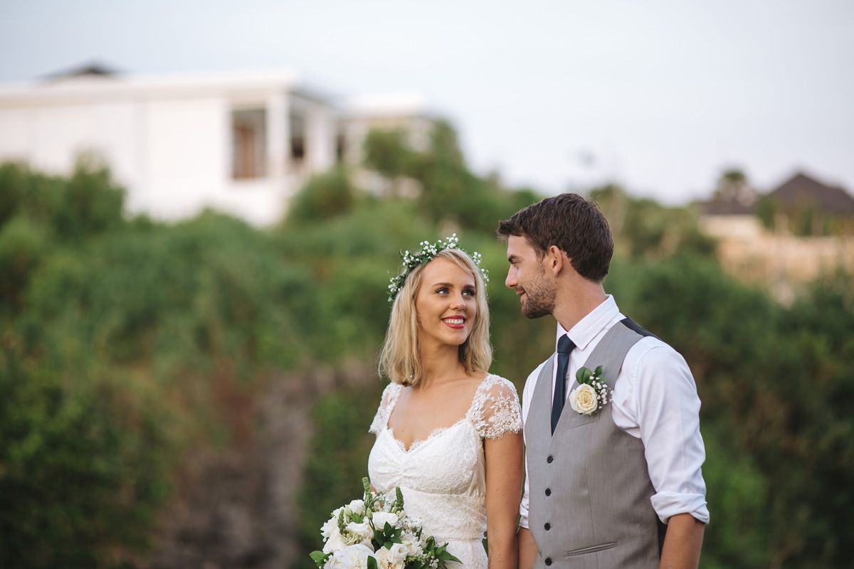 A wedding couple poses together against a scenic outdoor backdrop during their special day.