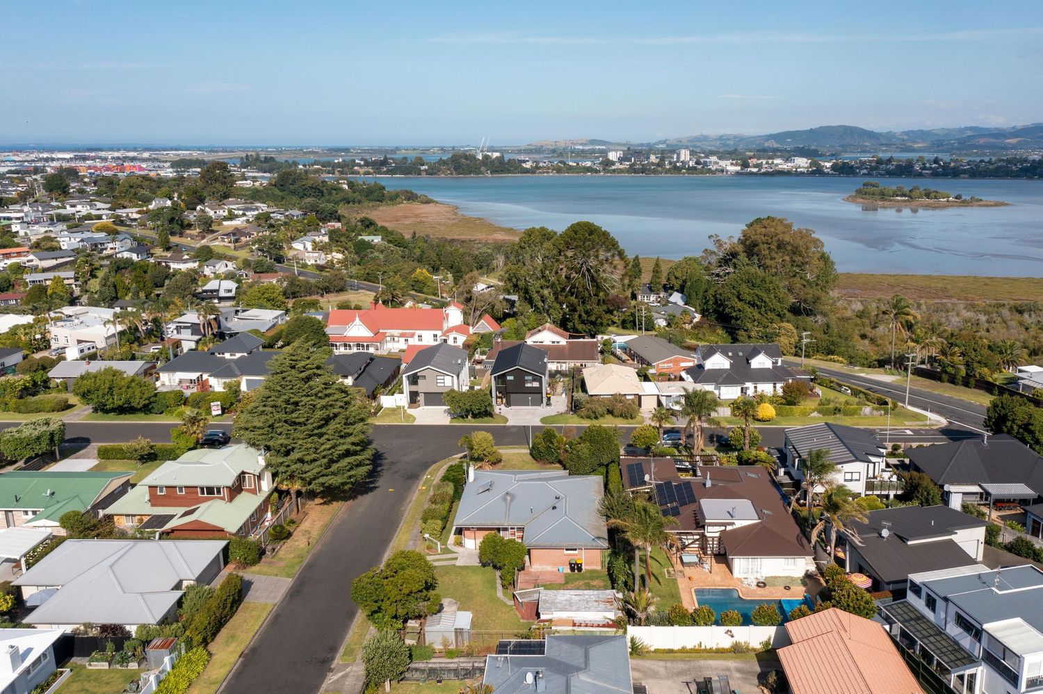 Panoramic coastal suburb view showing residential homes and streets along the waterfront in a seaside community.